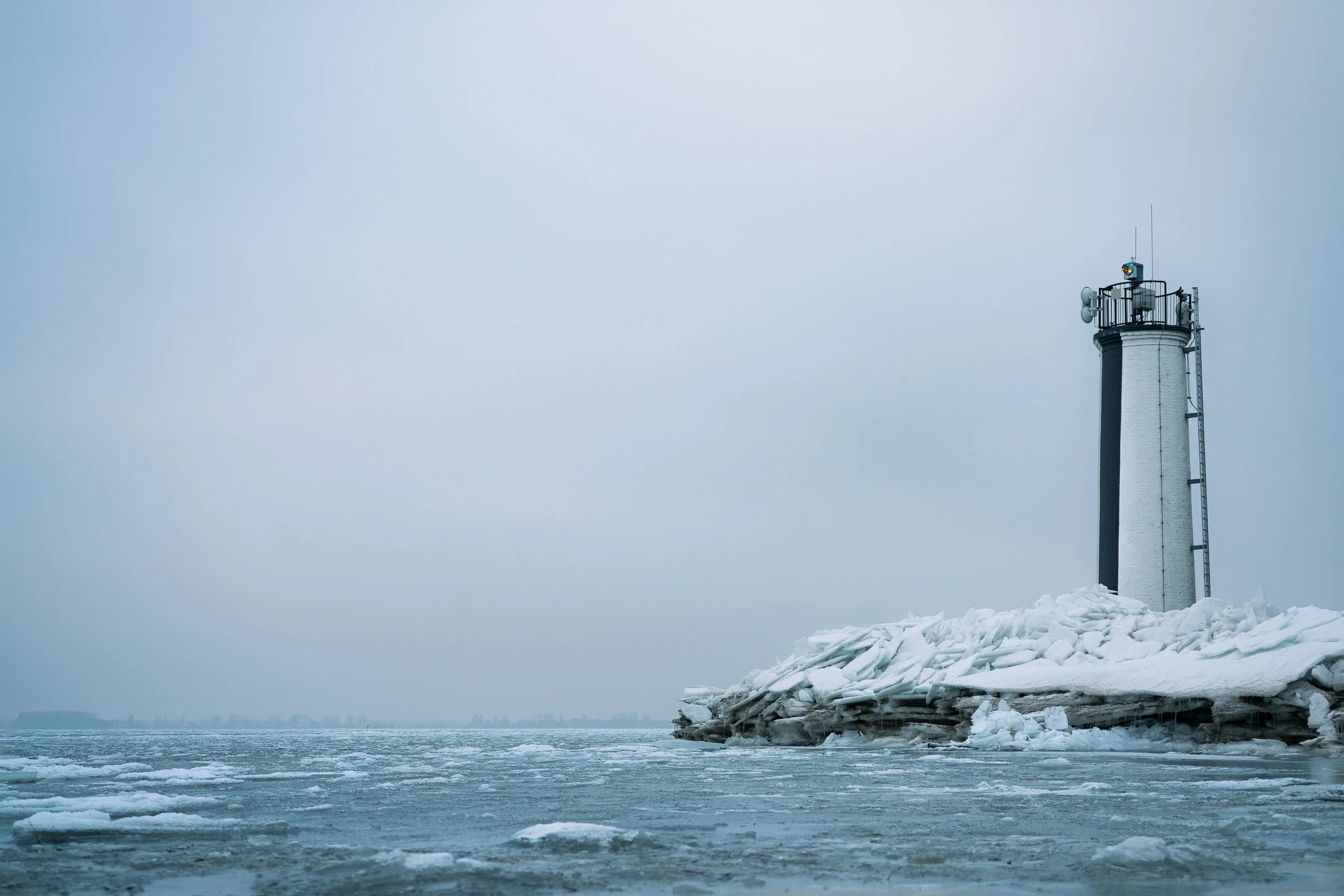 Leuchtturm auf einer eisbedeckten Küste bei frostigem Wetter