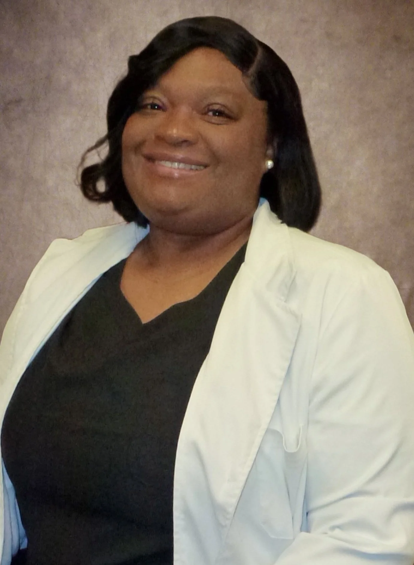 Smiling woman in a white coat with a black shirt.