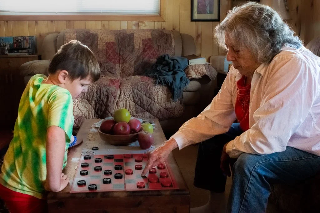 Rusted-Rose-Studios_Rusted-Rose-Studios_grandparent-child-playing-checkers-home_01_01.jpg