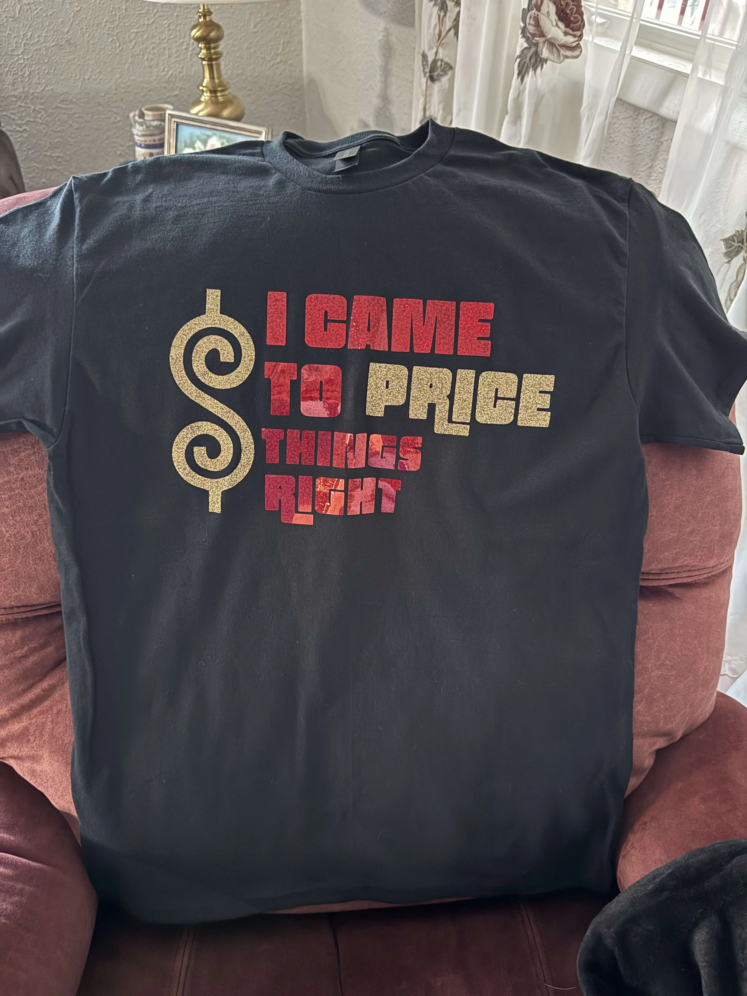 Black T-shirt with a gold and red graphic design that reads 'I CAME TO PRICE THINGS RIGHT' alongside a stylized gold dollar sign symbol.