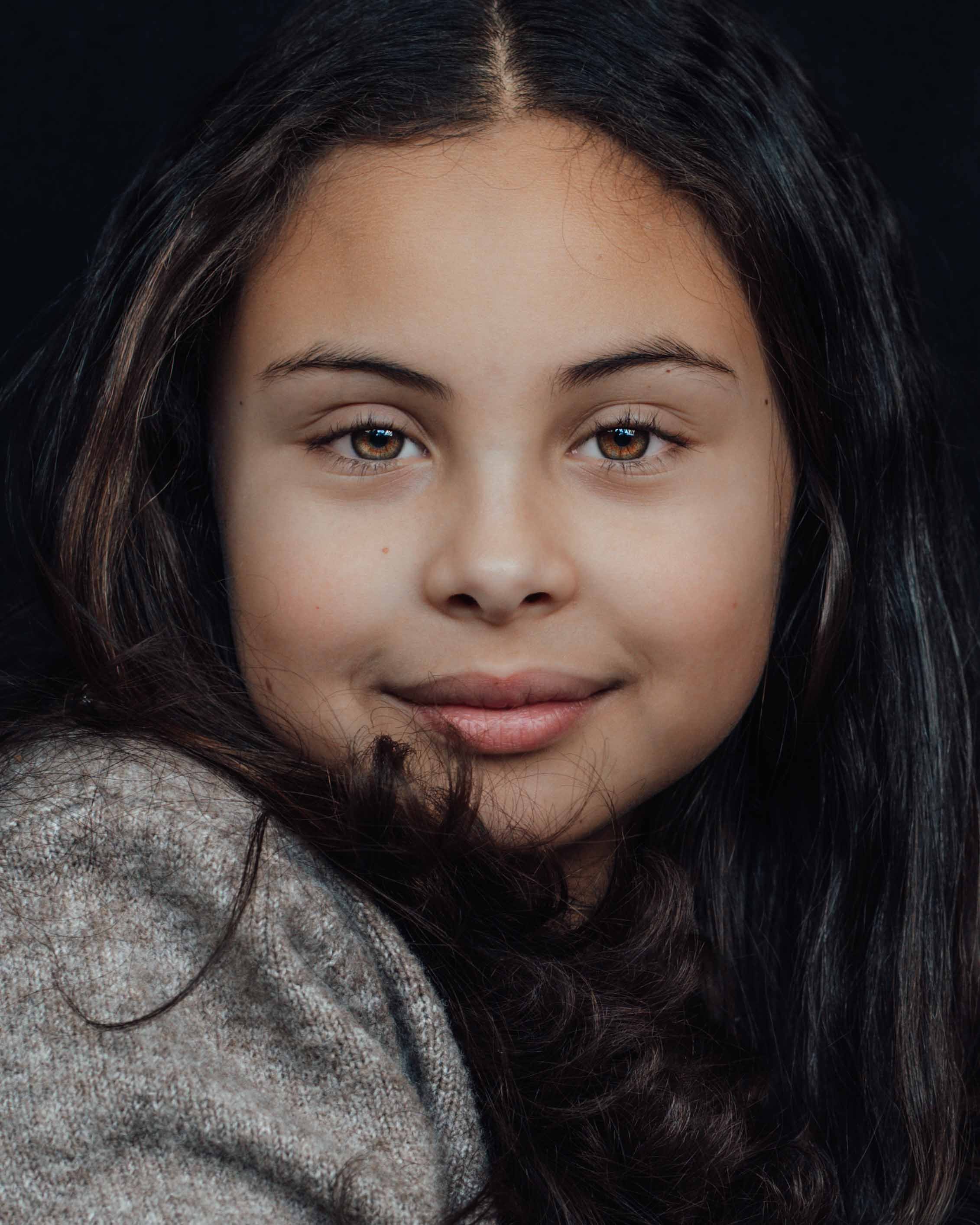 Close up kinderportret van een jong meisje van 10 jaar met zwarte achtergrond