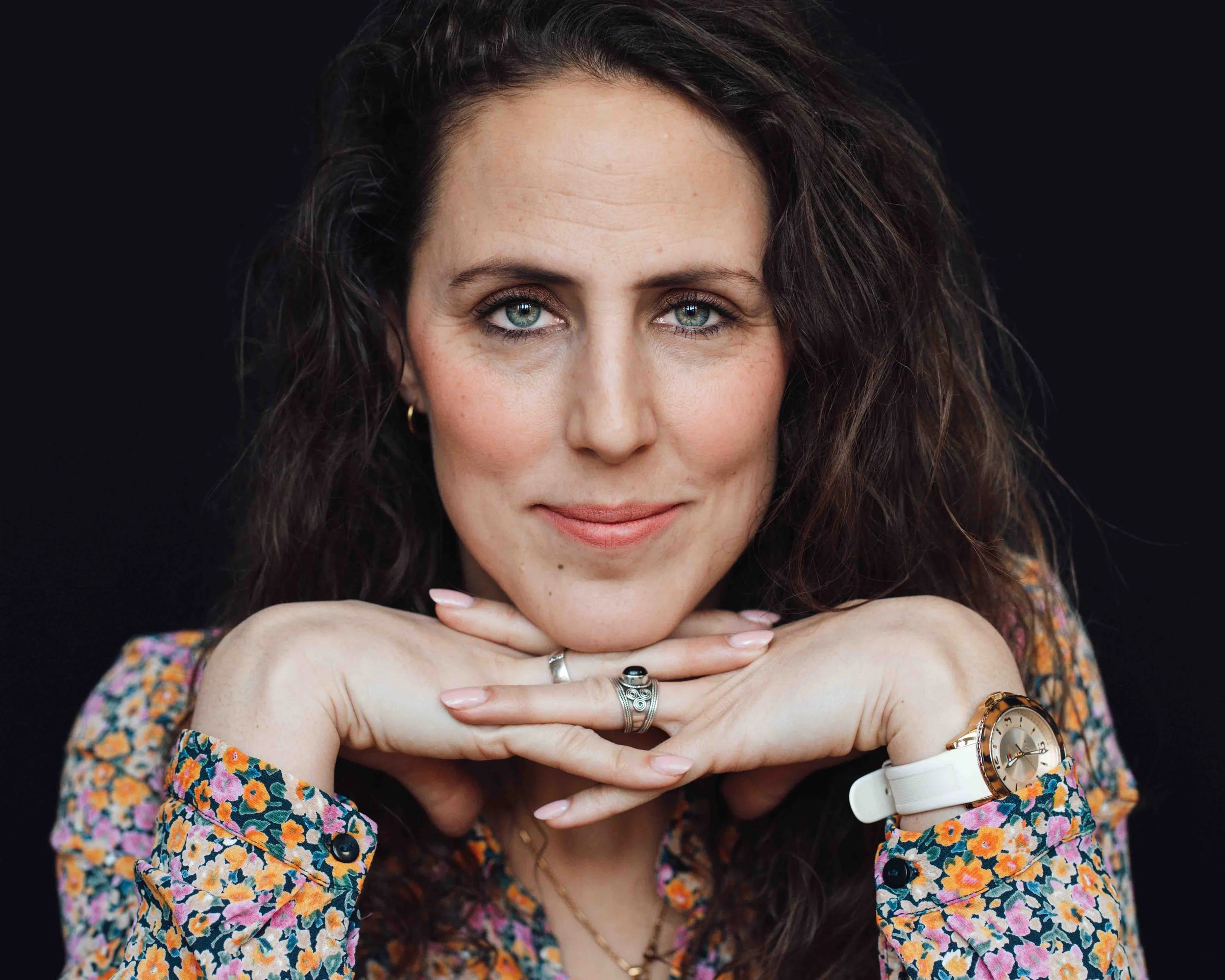 Krachtige professionele portretfoto van een jonge vrouw met donkere krullen en zwarte achtergrond