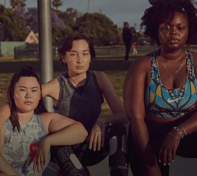 Three women sitting outdoors in a park.