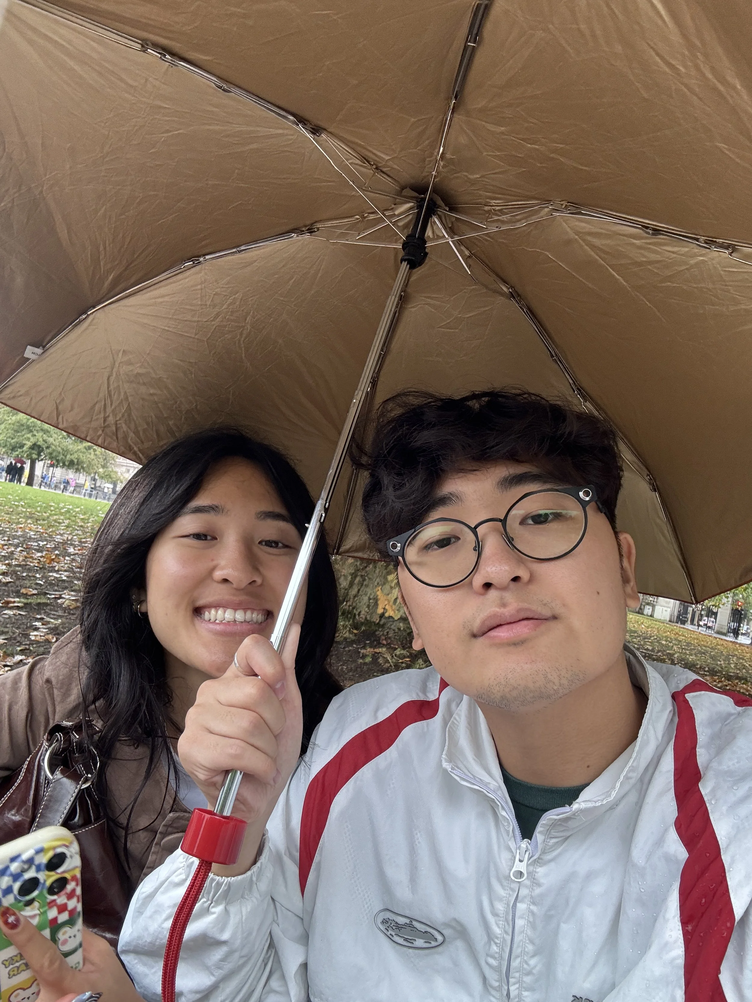 bannah and beiji waiting out the rain in london - this trip made me feel so complete, all thanks to you
