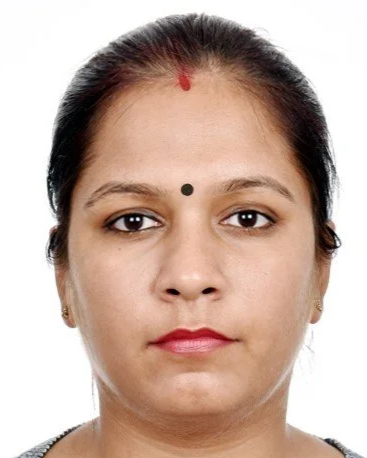 Close-up of a woman with a red mark on her forehead and a black dot on her nose, looking directly at the camera.