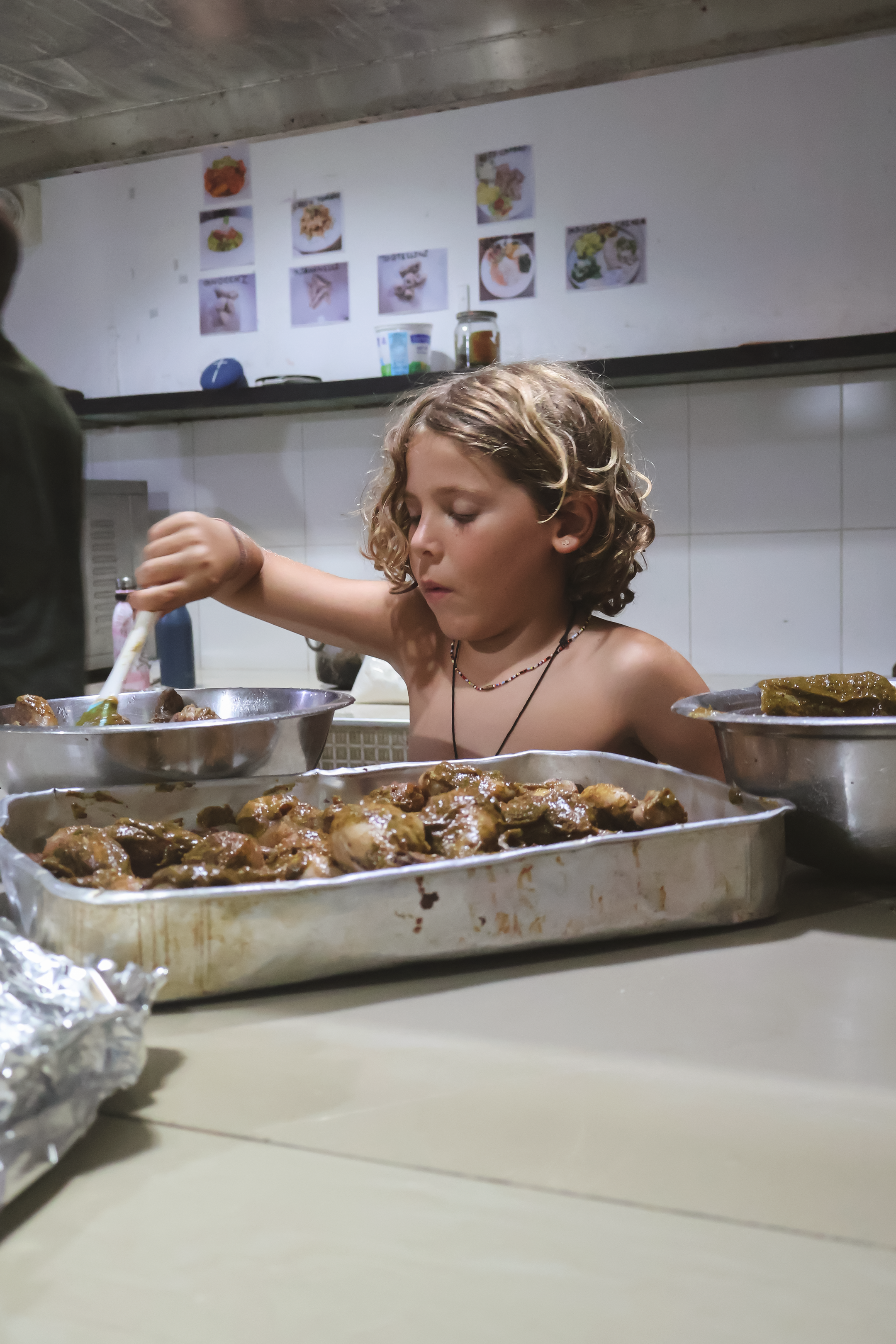 Child marinading chicken in a sri lankan kitchen