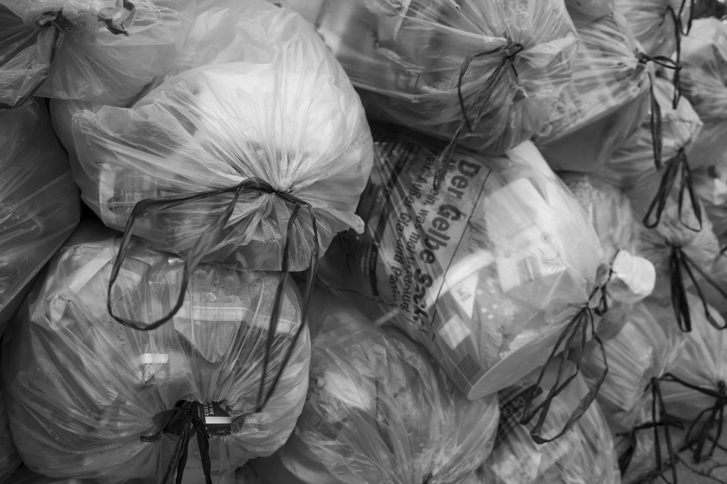 Bags of frozen food stacked together, tied with black strings.
