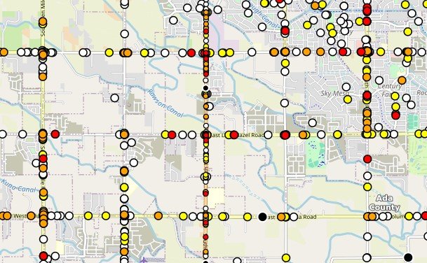 Map displaying a grid of colored dots representing data points across a city and surrounding area, with roads and geographic features visible.