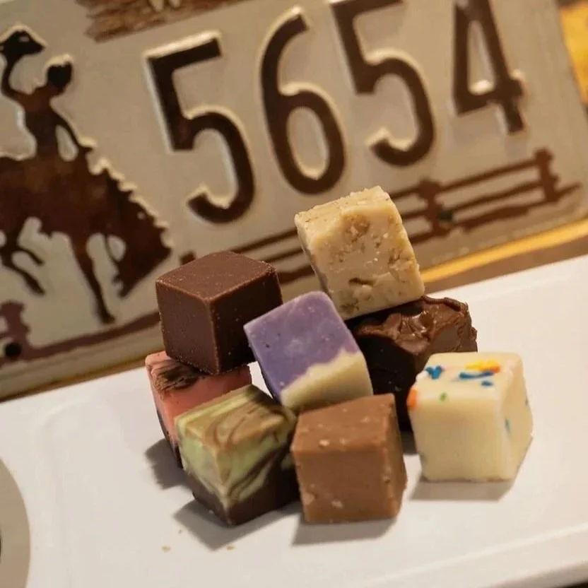 An assortment of assorted flavored chocolates on a white plate with a decorative sign or plaque in the background displaying the numbers 5654.
