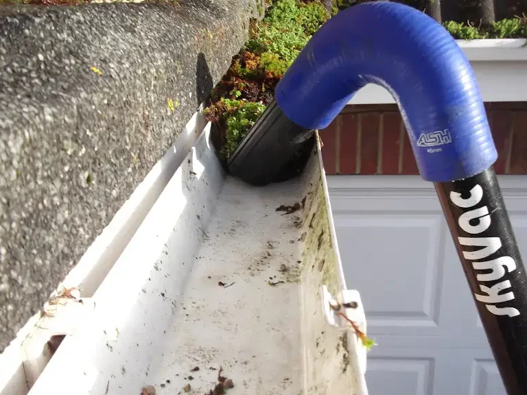 Clearing moss from gutters using a Sky Vac gutter vacuum for professional gutter cleaning in Hertfordshire.