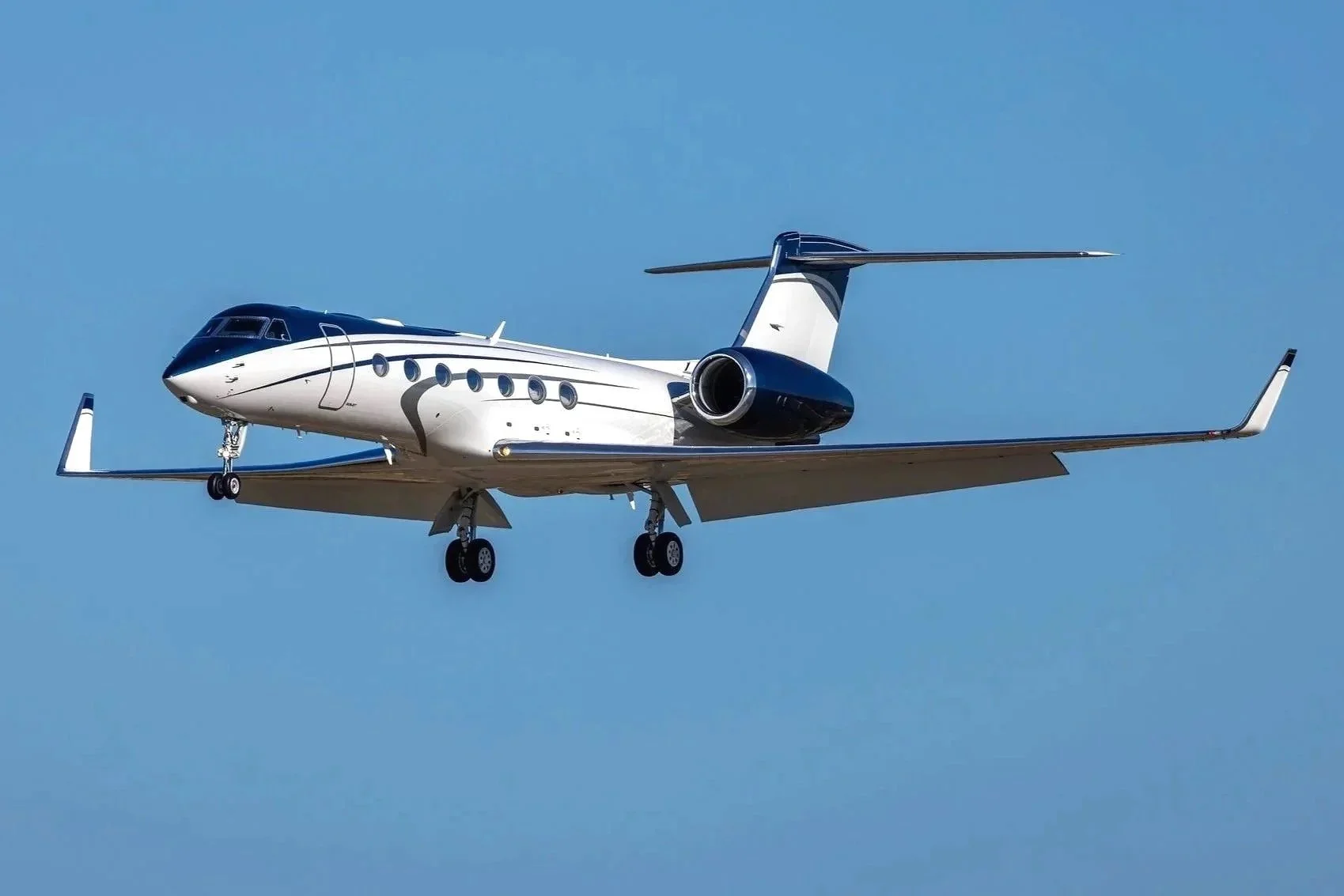 A blue and white Gulfstream G550 flies over Lake Tahoe.