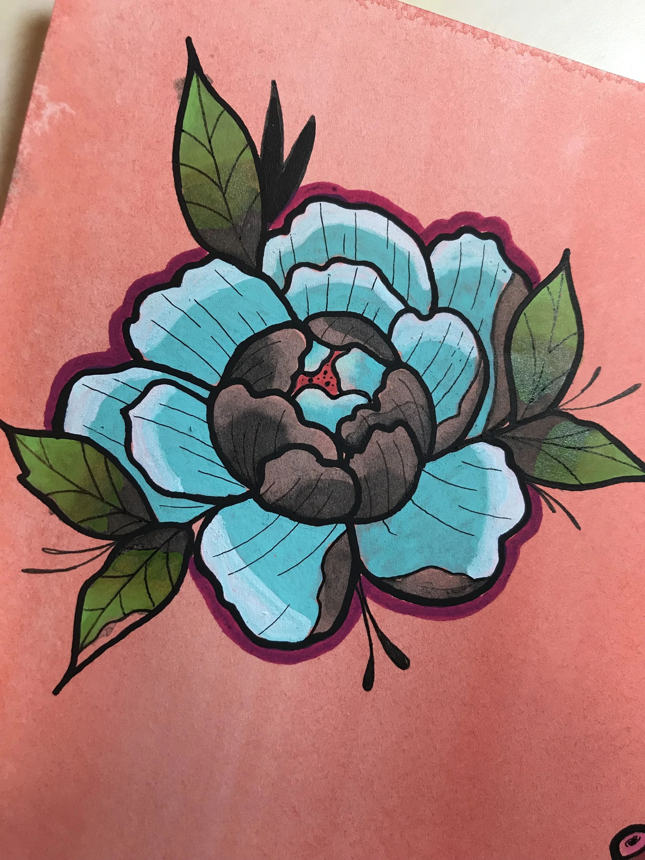 A drawing of a blue flower with black outlines and green leaves on pink paper.