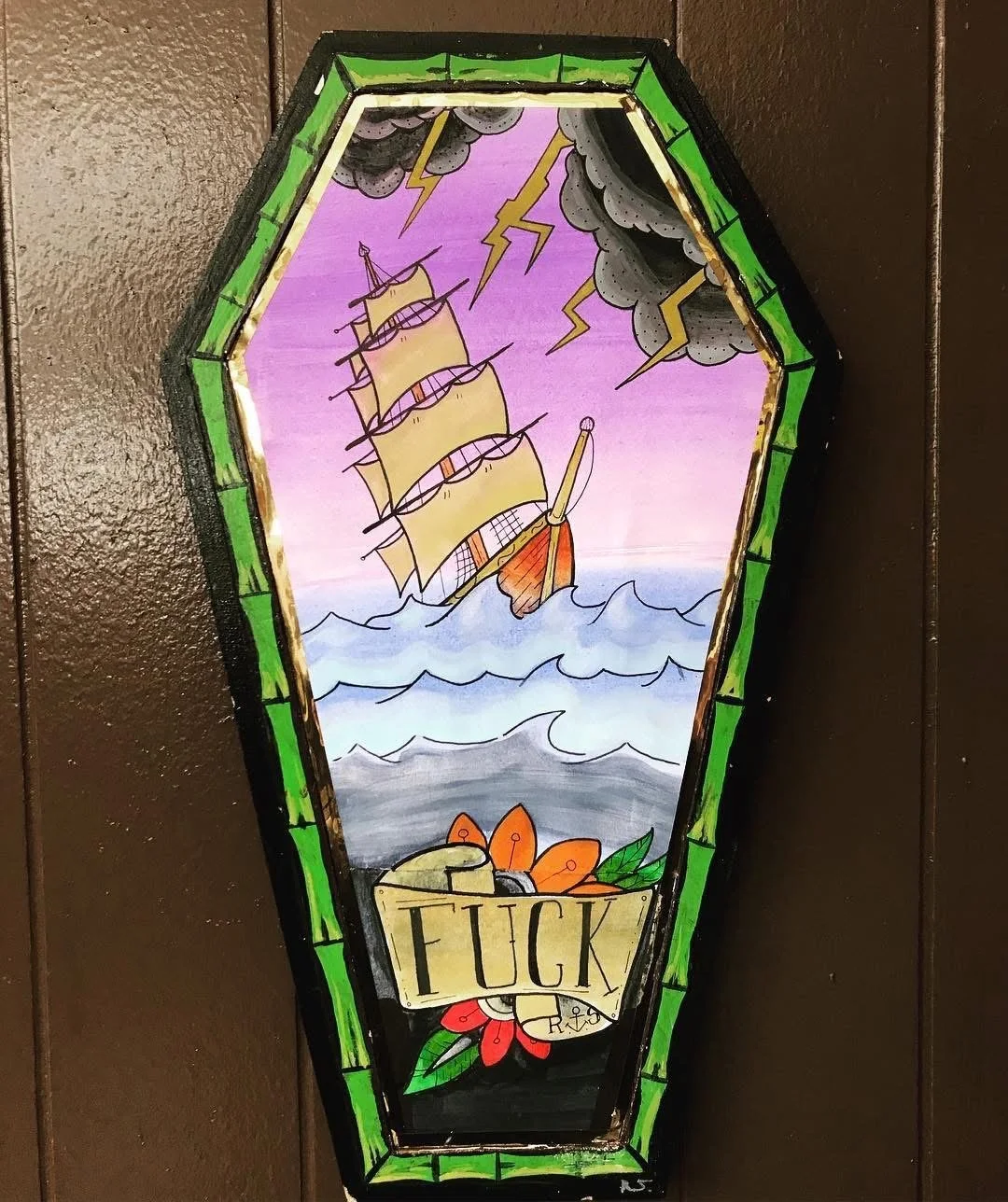 Colorful stained glass window with a pirate ship sailing on the ocean, dark storm clouds with lightning in the sky, and a banner with the word 'FUCK' at the bottom.
