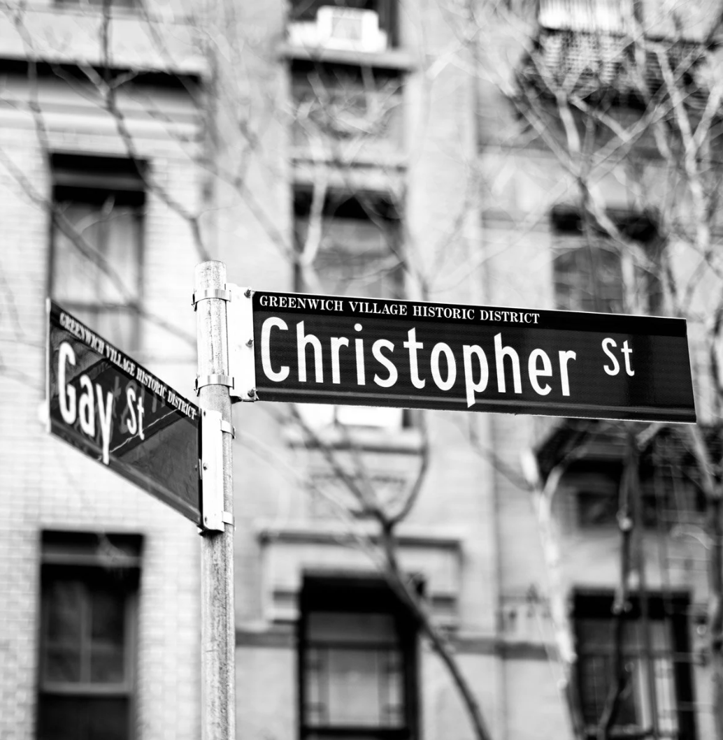 Street signs showing the intersection of Christopher Street and Gay Street in Greenwich Village, New York City, in black and white.