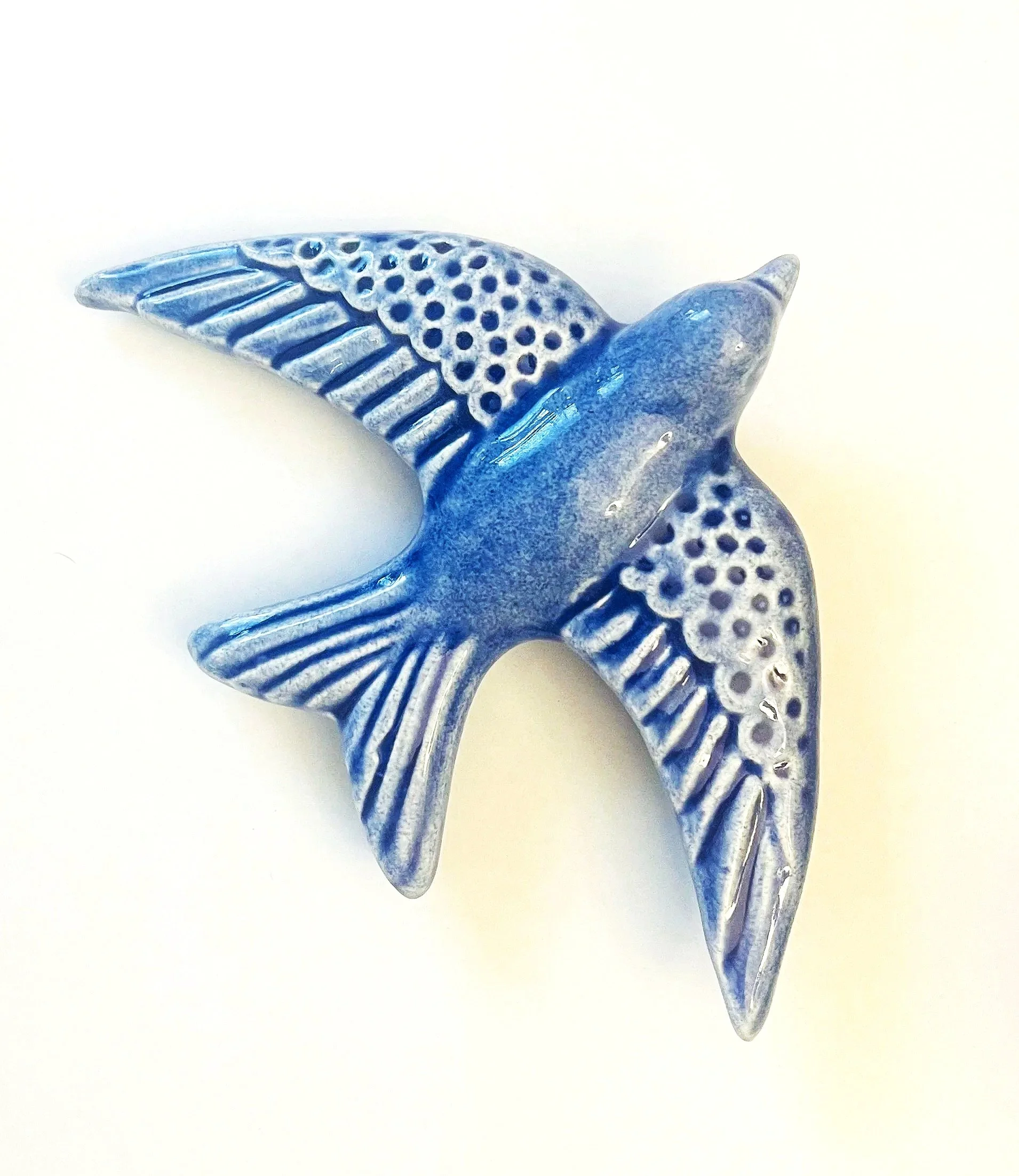 Blue decorative hummingbird figurine with detailed wings, set against a plain white background.