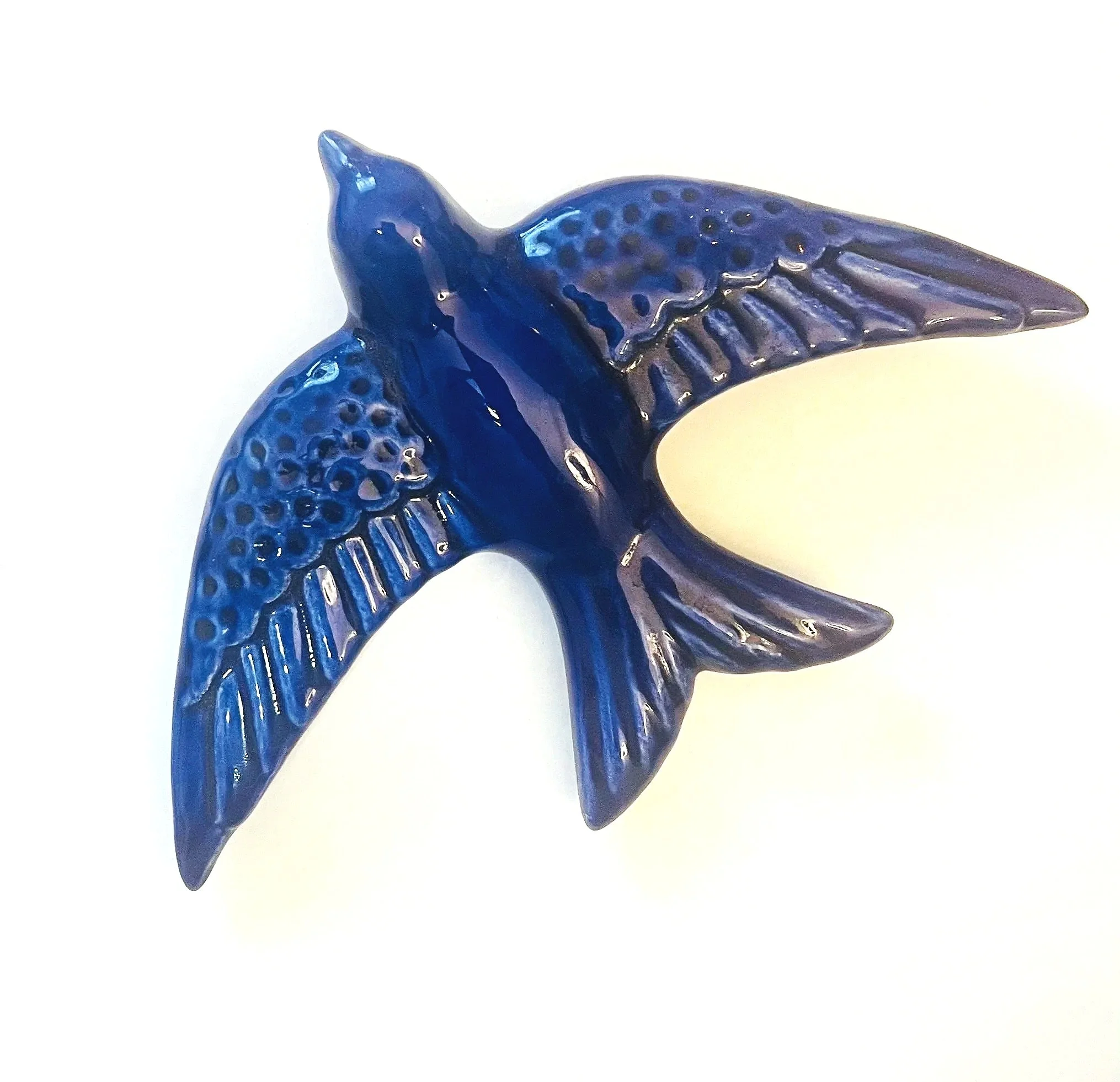 Blue glass whale figurine with detailed fins and textured body, set against a plain white background.