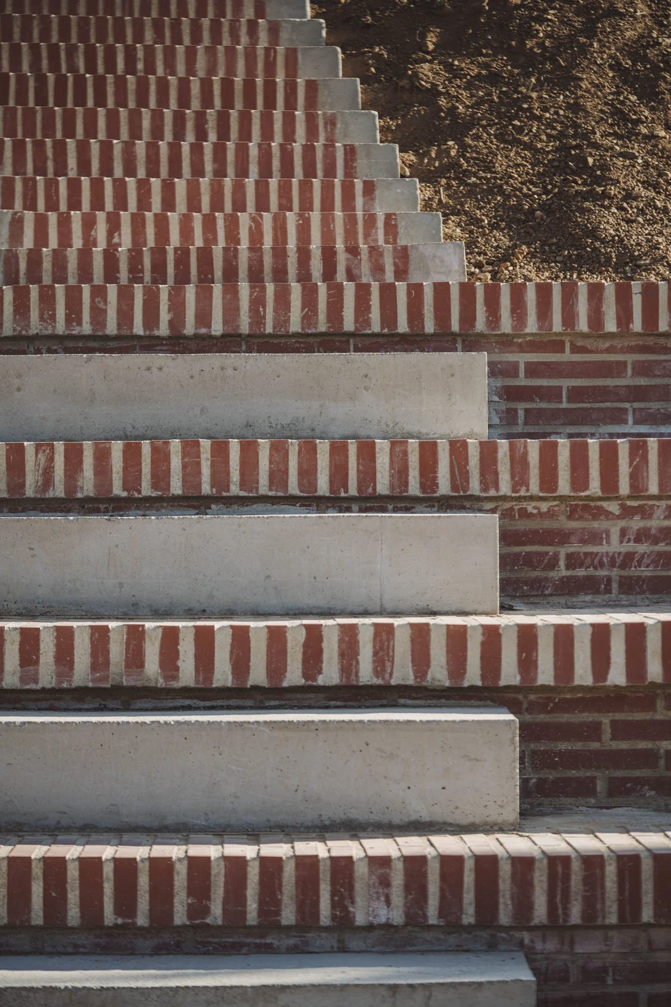 Escalera de ladrillos rojos con escalones de concreto, en construcción