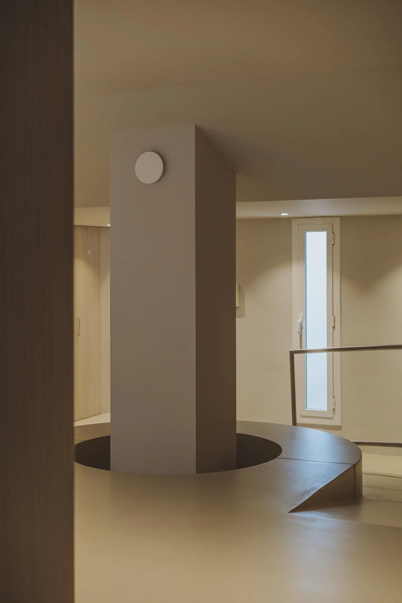 Espacio interior con columnas, una ventana y barandal.