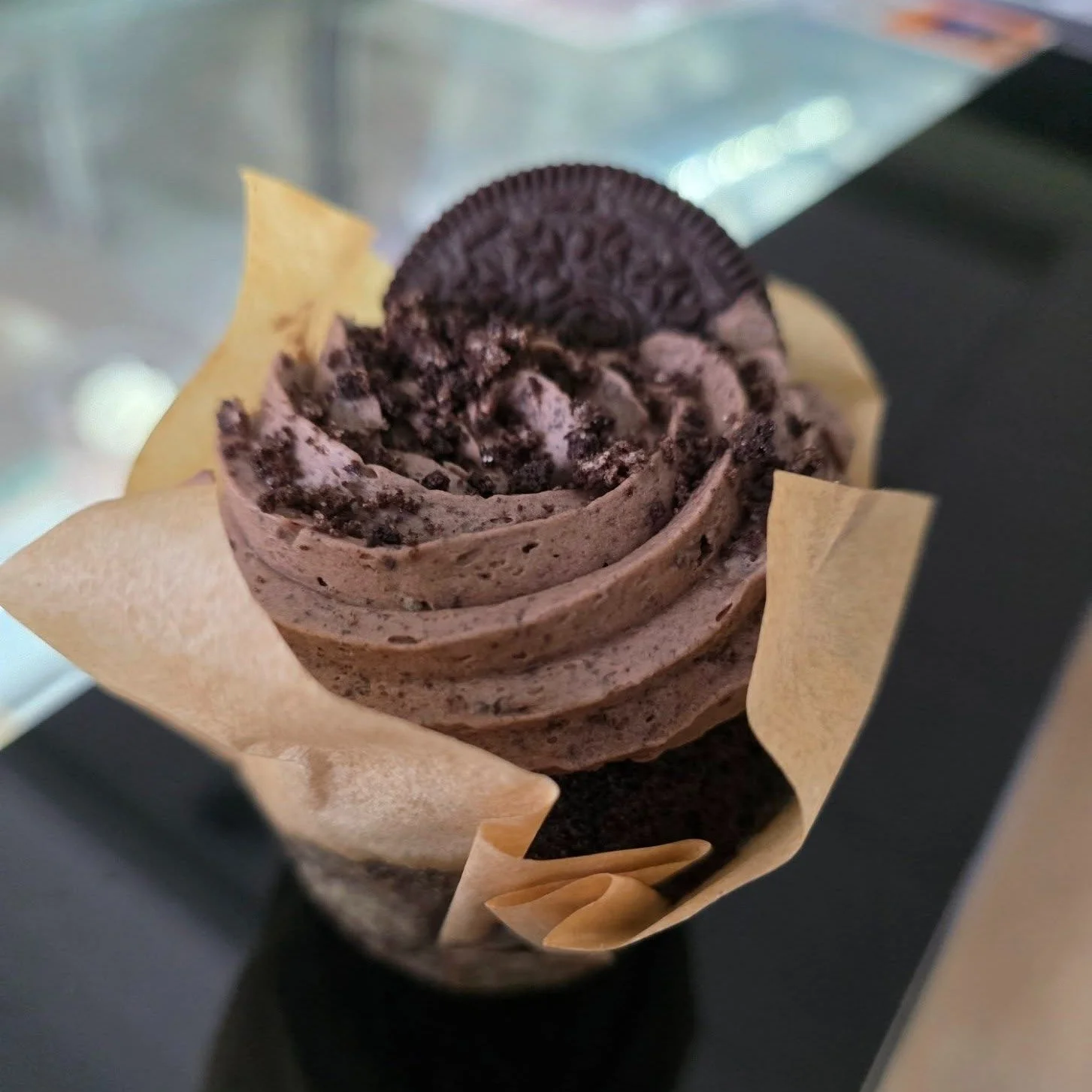 Chocolate cupcake with chocolate frosting and an Oreo cookie on top.