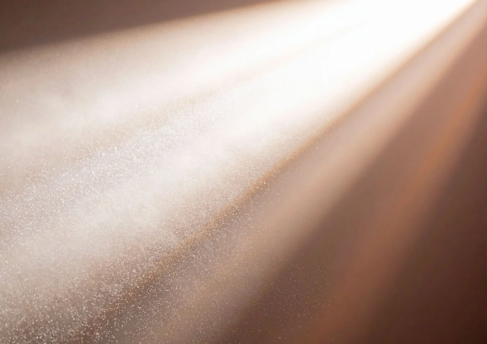 Nahaufnahme von glitzerndem, goldfarbenem Stoff mit schimmernder Oberfläche und weichem Lichtreflexen.