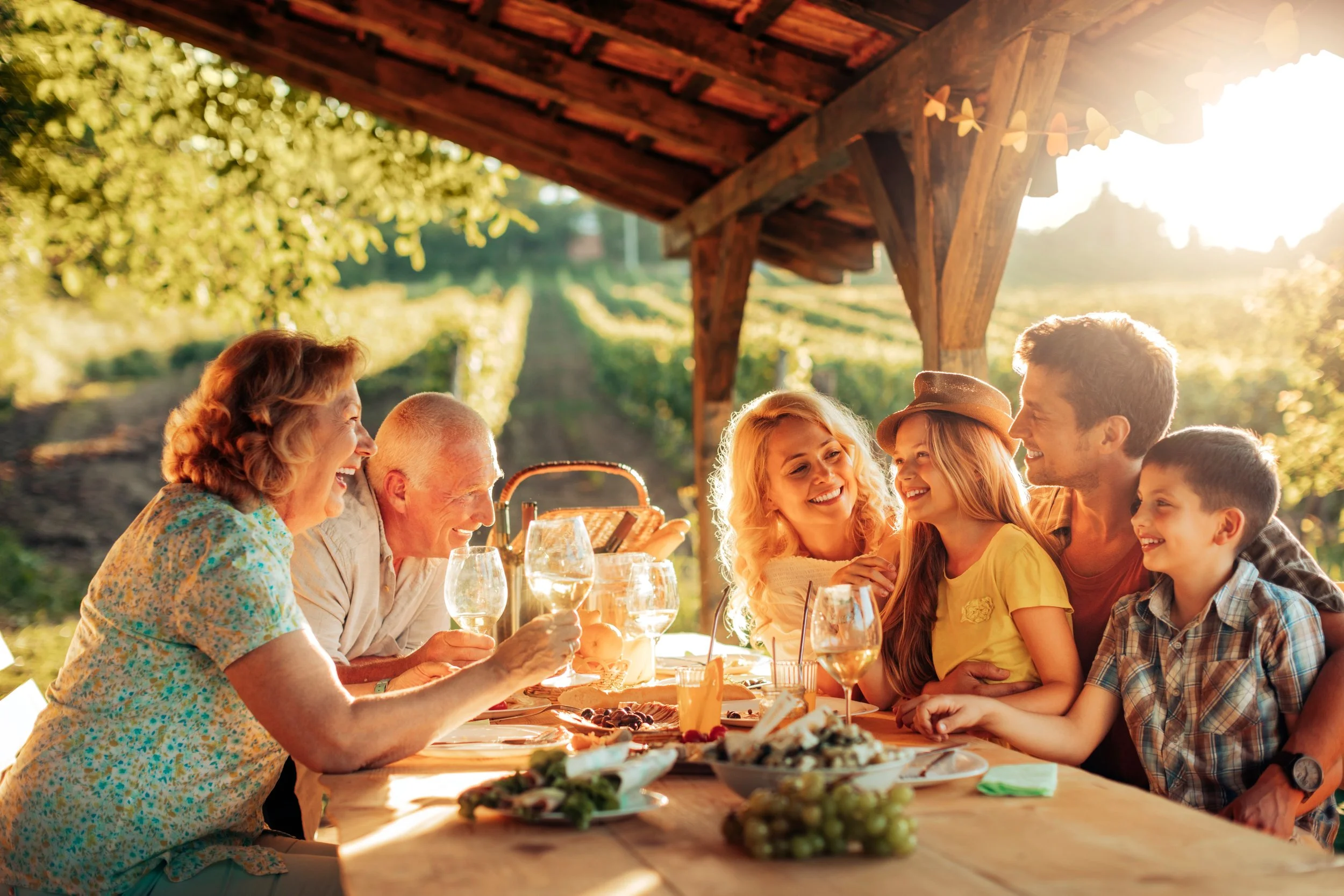 A happy multigenerational family gathered for a meal on an outdoor porch