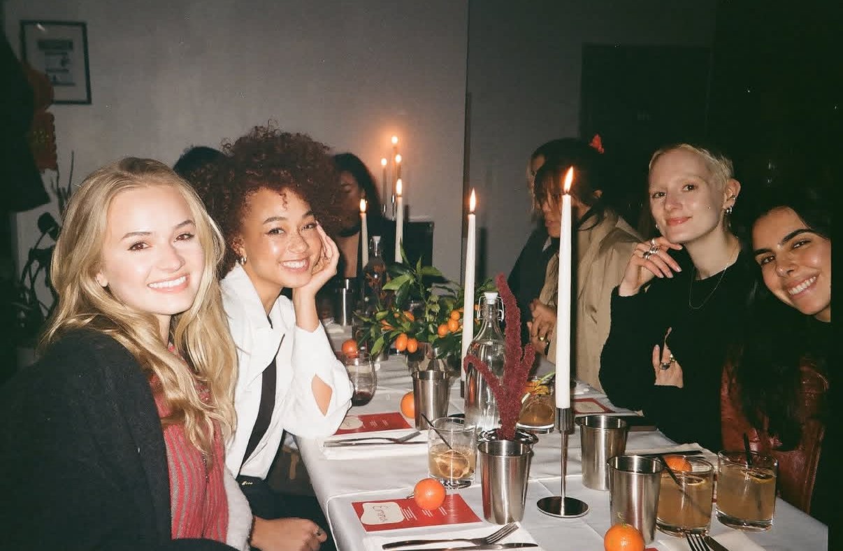 Group of women sitting at a decorated dinner table during a celebration or dinner party.