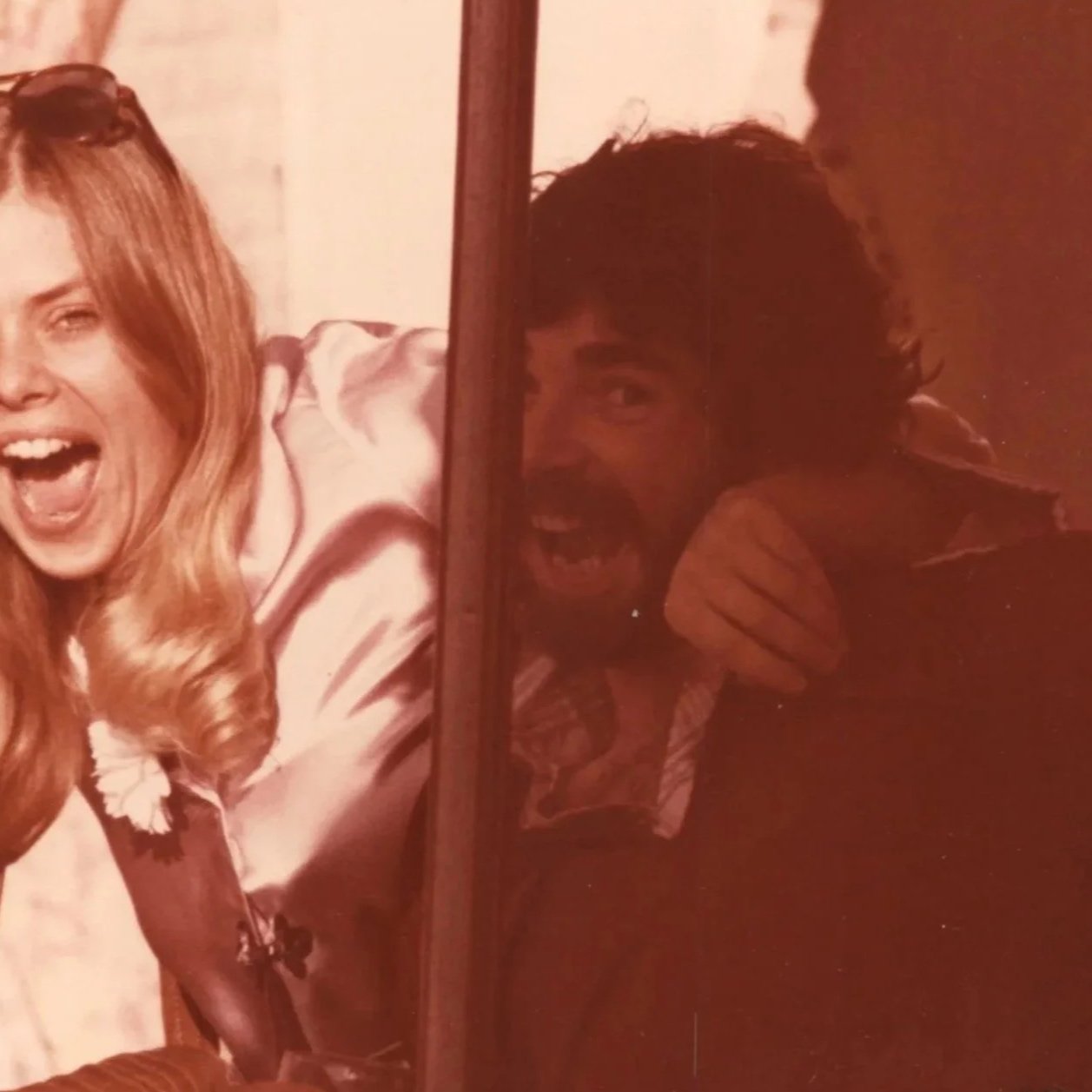 A split photo of two people, one woman smiling with blonde hair on the left, and one man with dark hair and a beard smiling on the right, both appearing joyful.