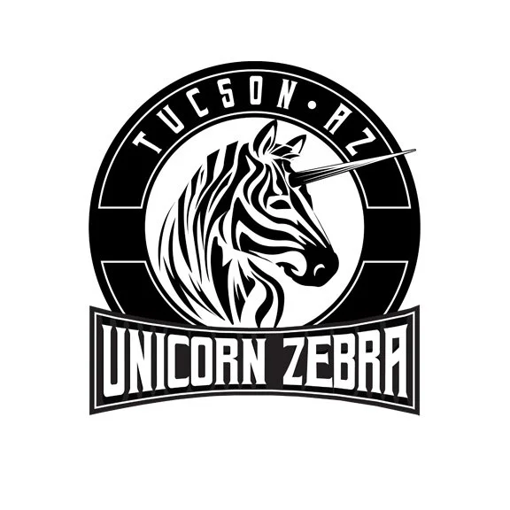 A monochrome logo featuring a zebra with a unicorn horn, encircled by the text 'Tucson AZ' at the top and 'Unicorn Zebra' at the bottom.