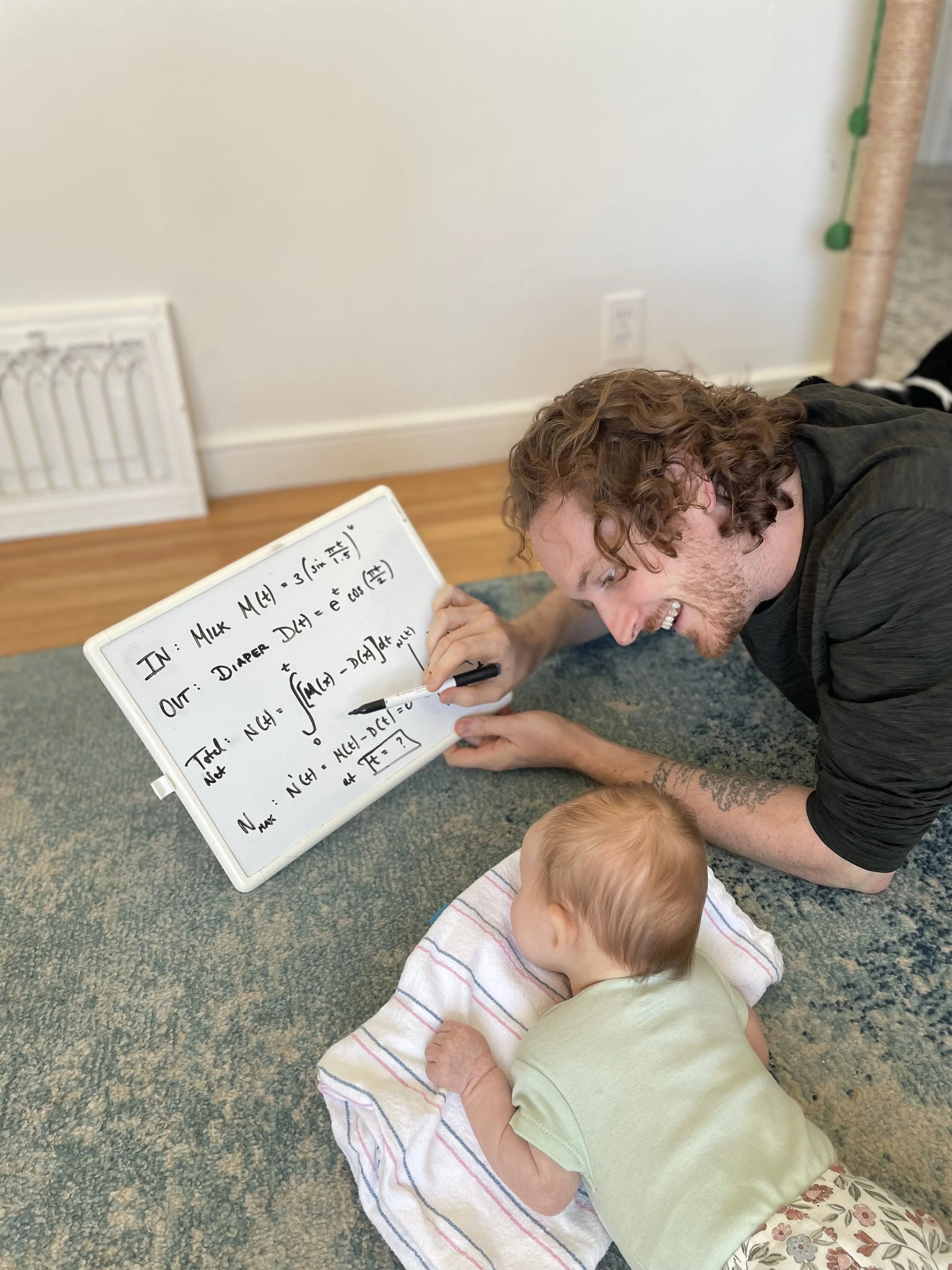 An image of me attempting to teach my infant daughter the basics of Calculus. It's going okay.