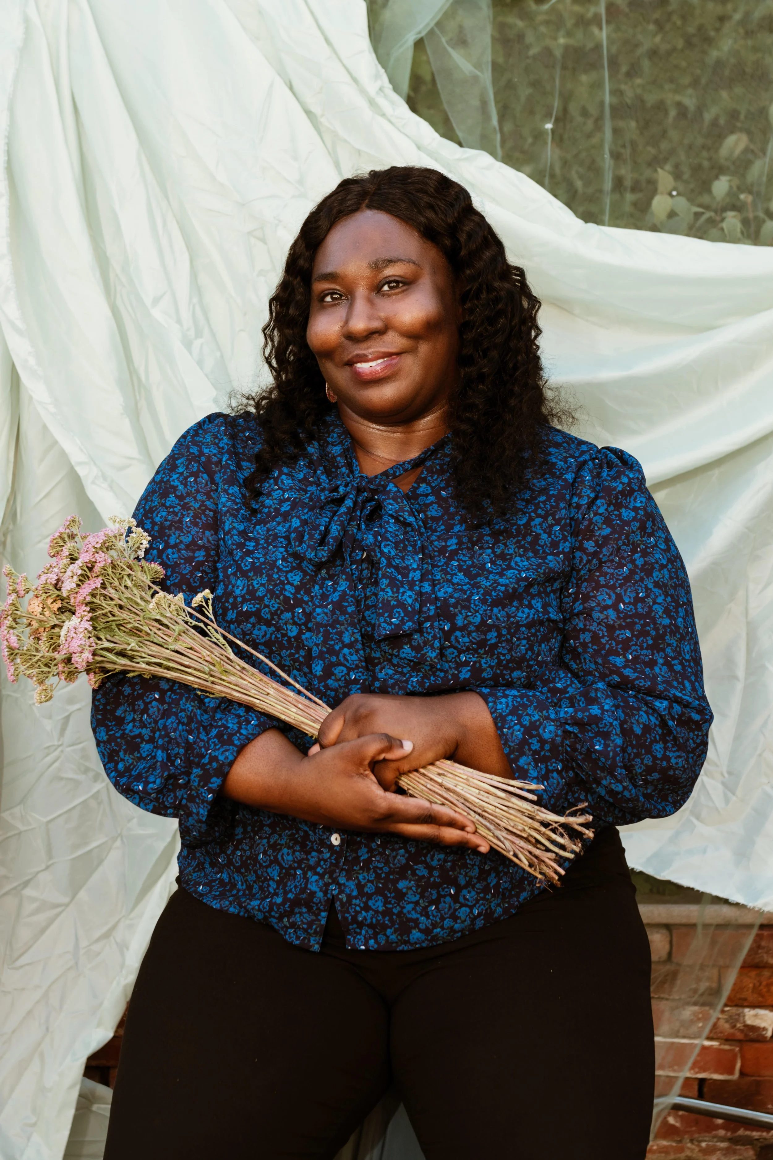 Black woman therapist holding flowers with a smile