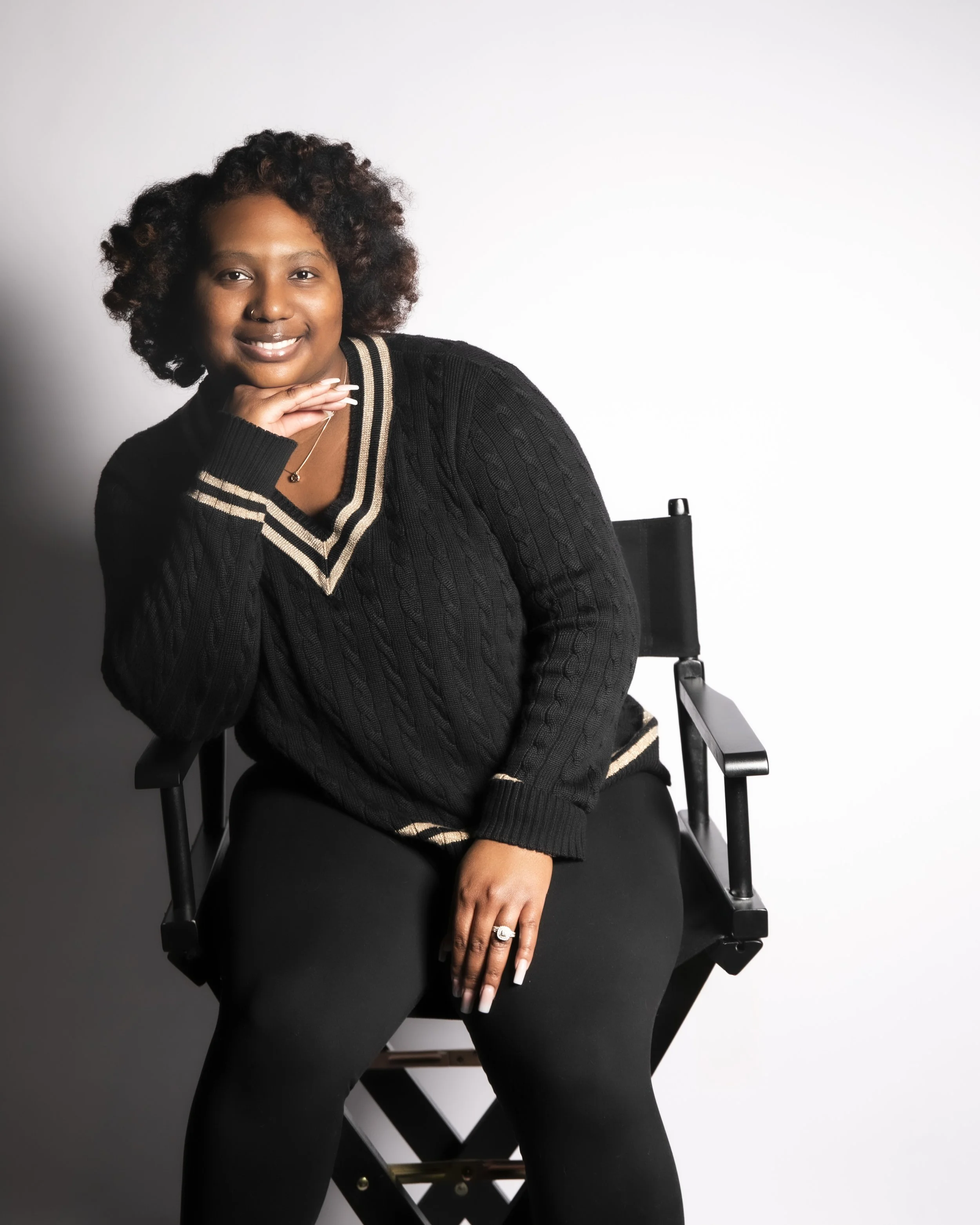 Smiling woman seated in a director’s chair during a personal branding session with T3 Mobile Studio.