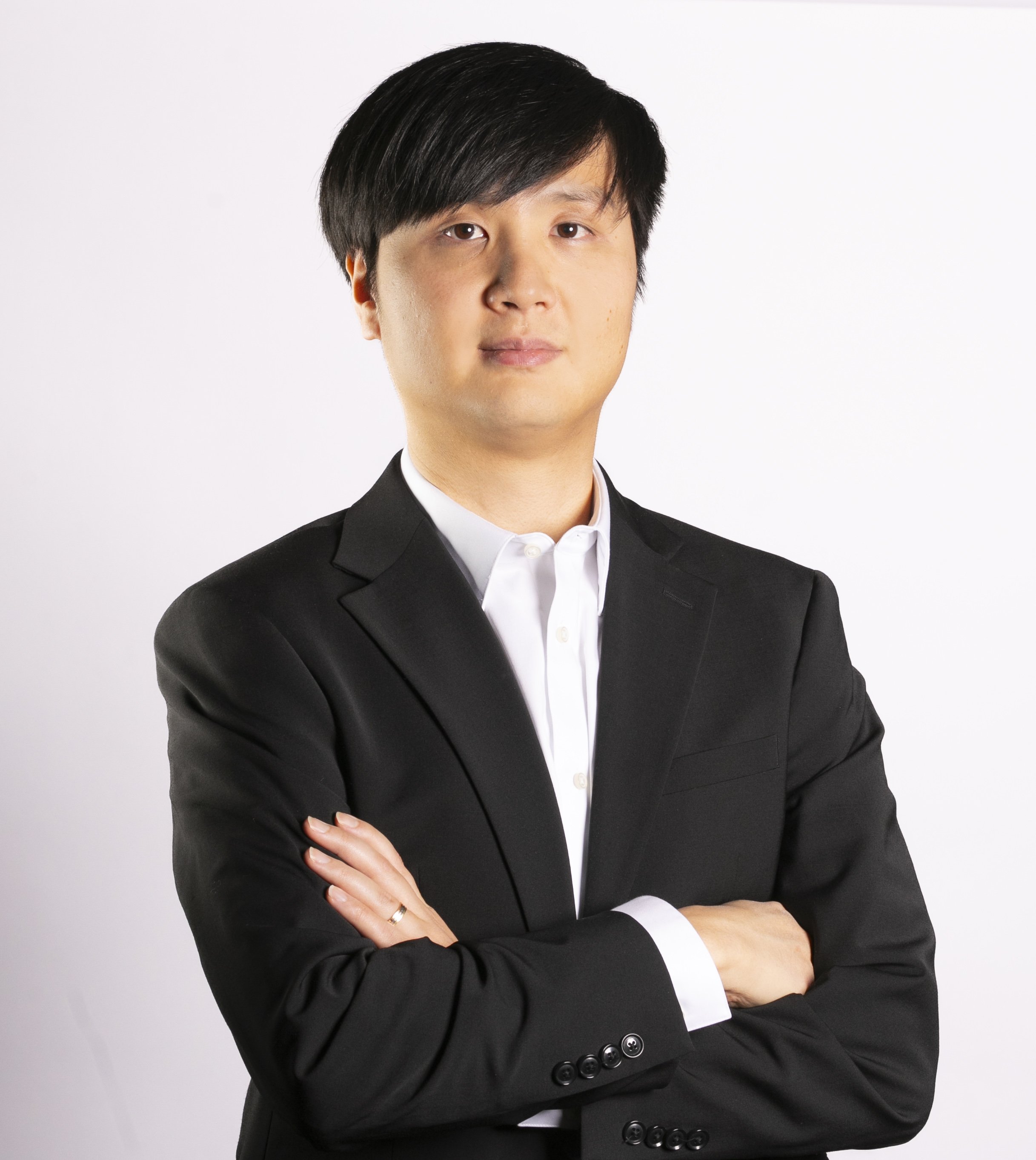 Young man in a black suit posing for a professional headshot with T3 Mobile Studio.