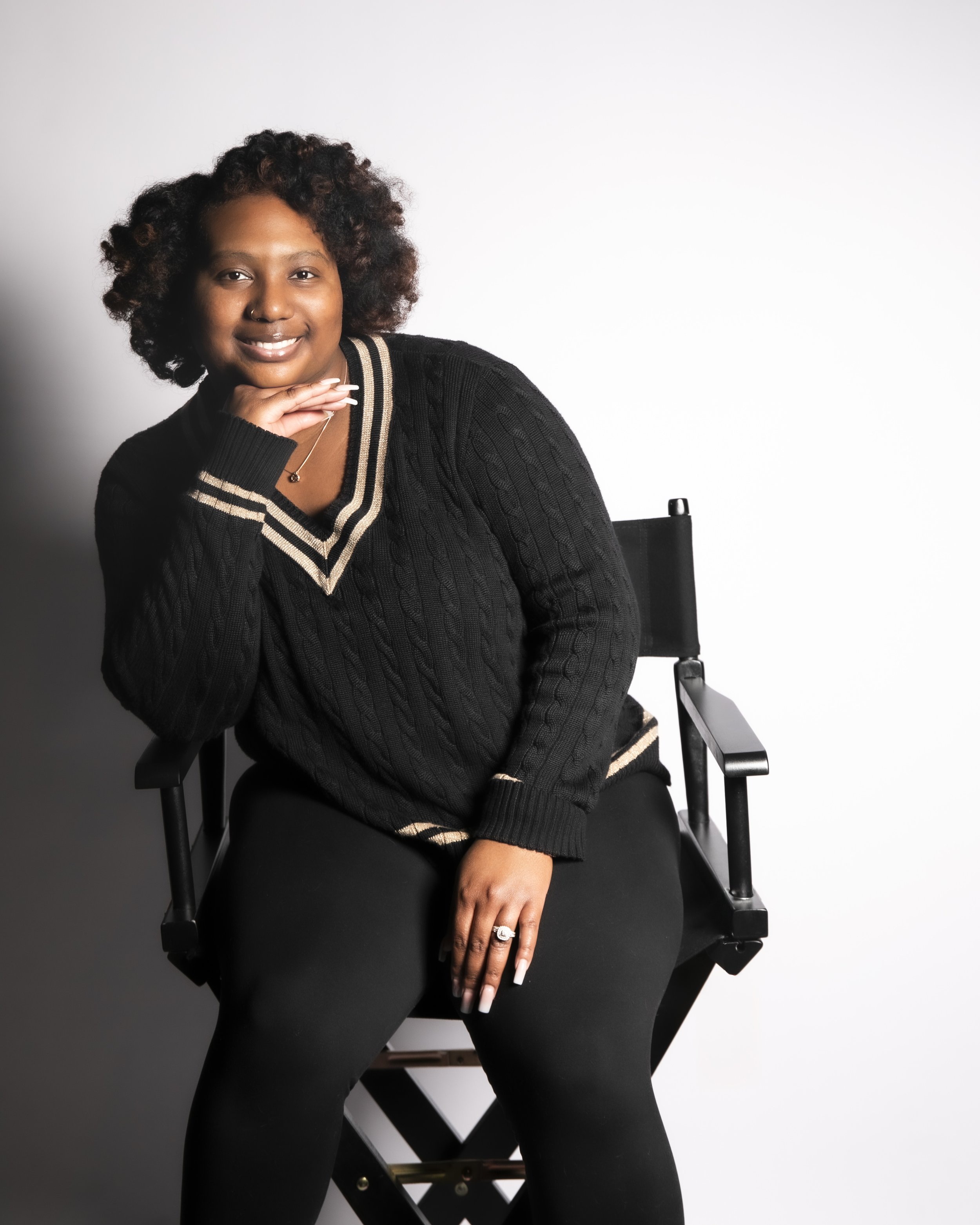 Smiling woman seated in a director’s chair during a personal branding portrait session with T3 Mobile Studio.