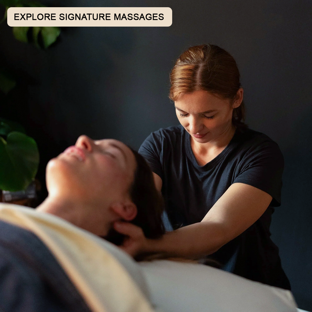 Woman massaging a client on a massage table. Massaging the back of her neck.