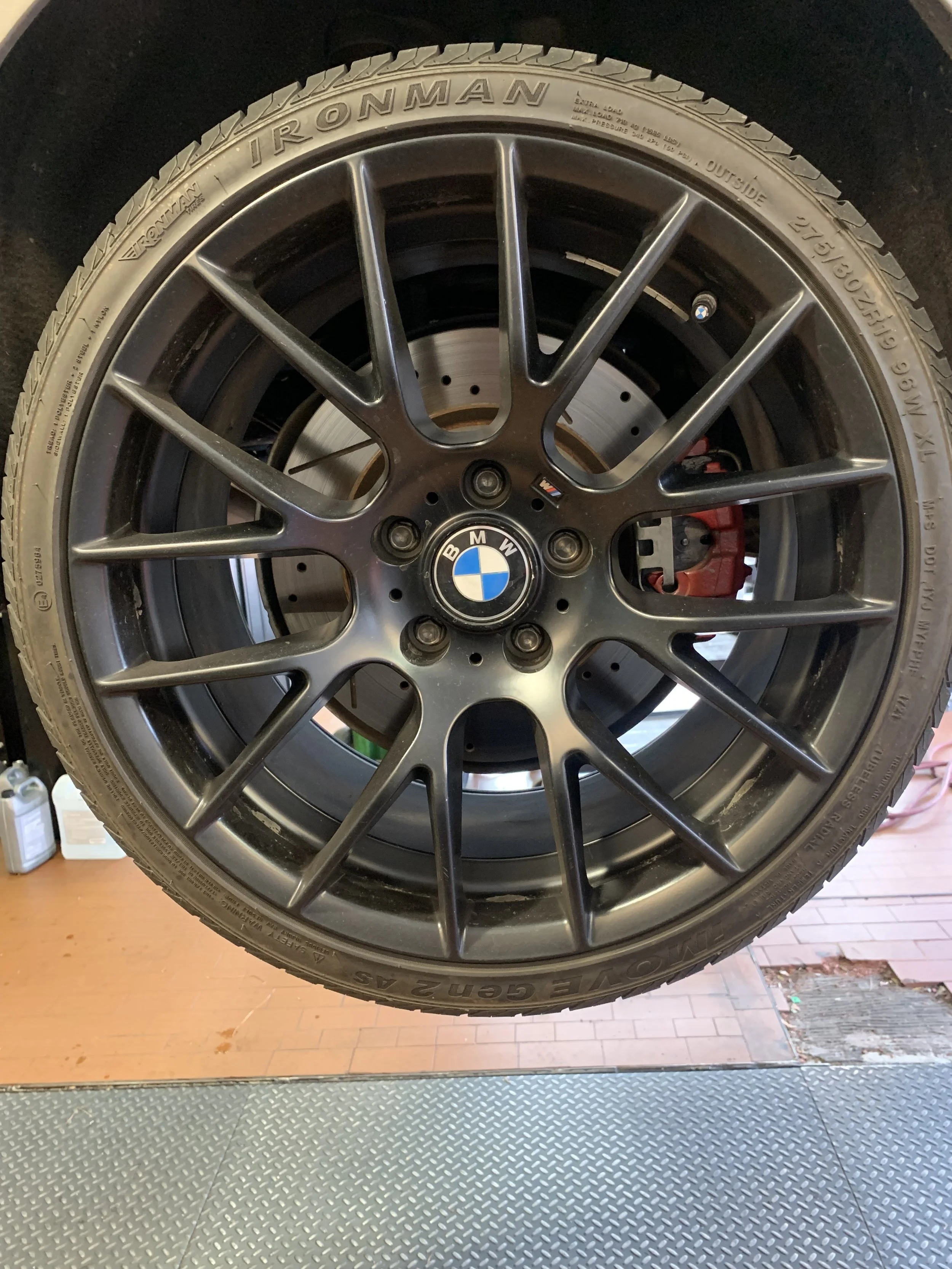 Close-up of a BMW car wheel with an alloy rim and a Yokohama tire, with the brake caliper visible behind the rim.