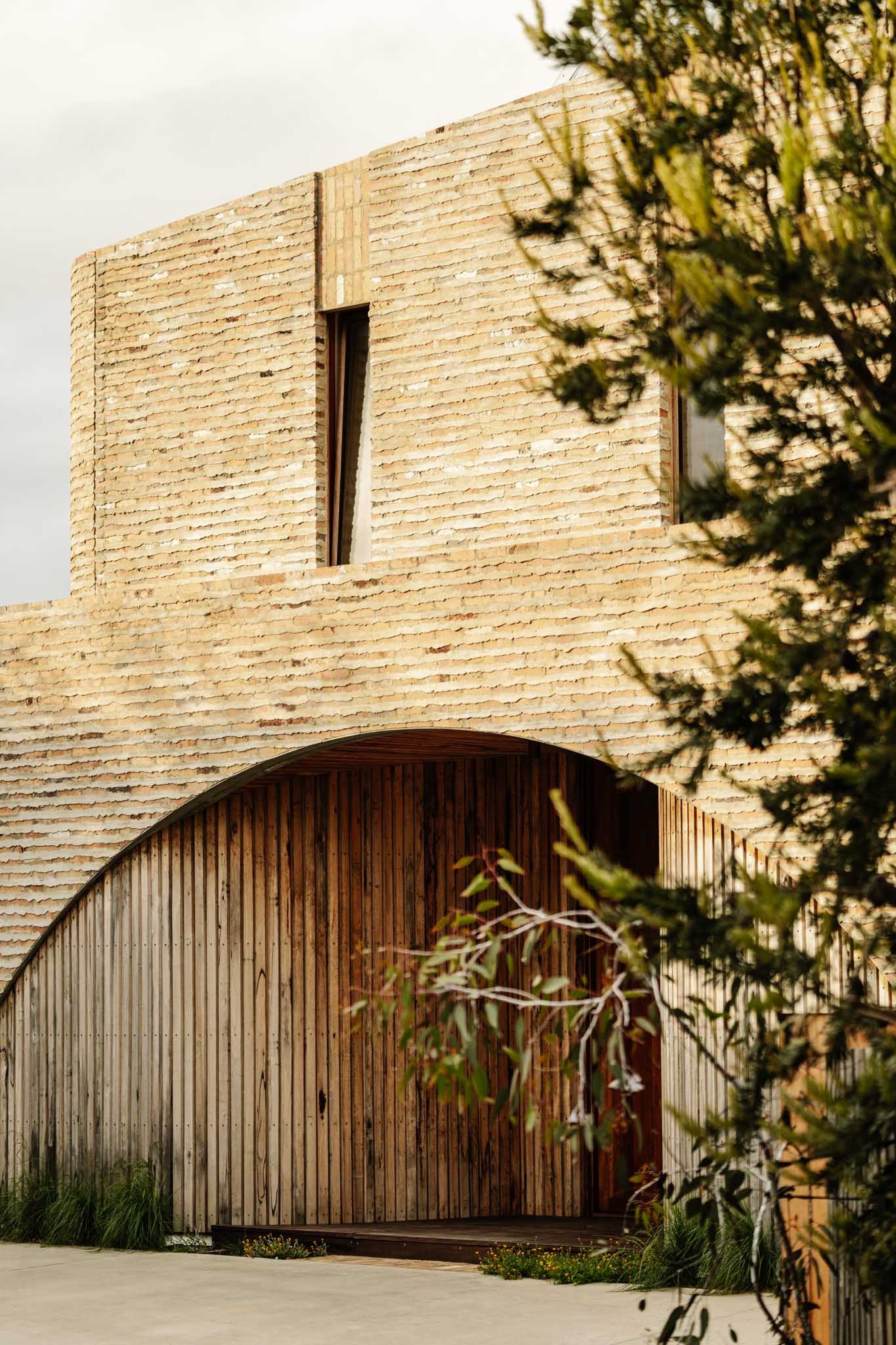 #tilt-scroll bagged brick and timber house with gum tree in foreground