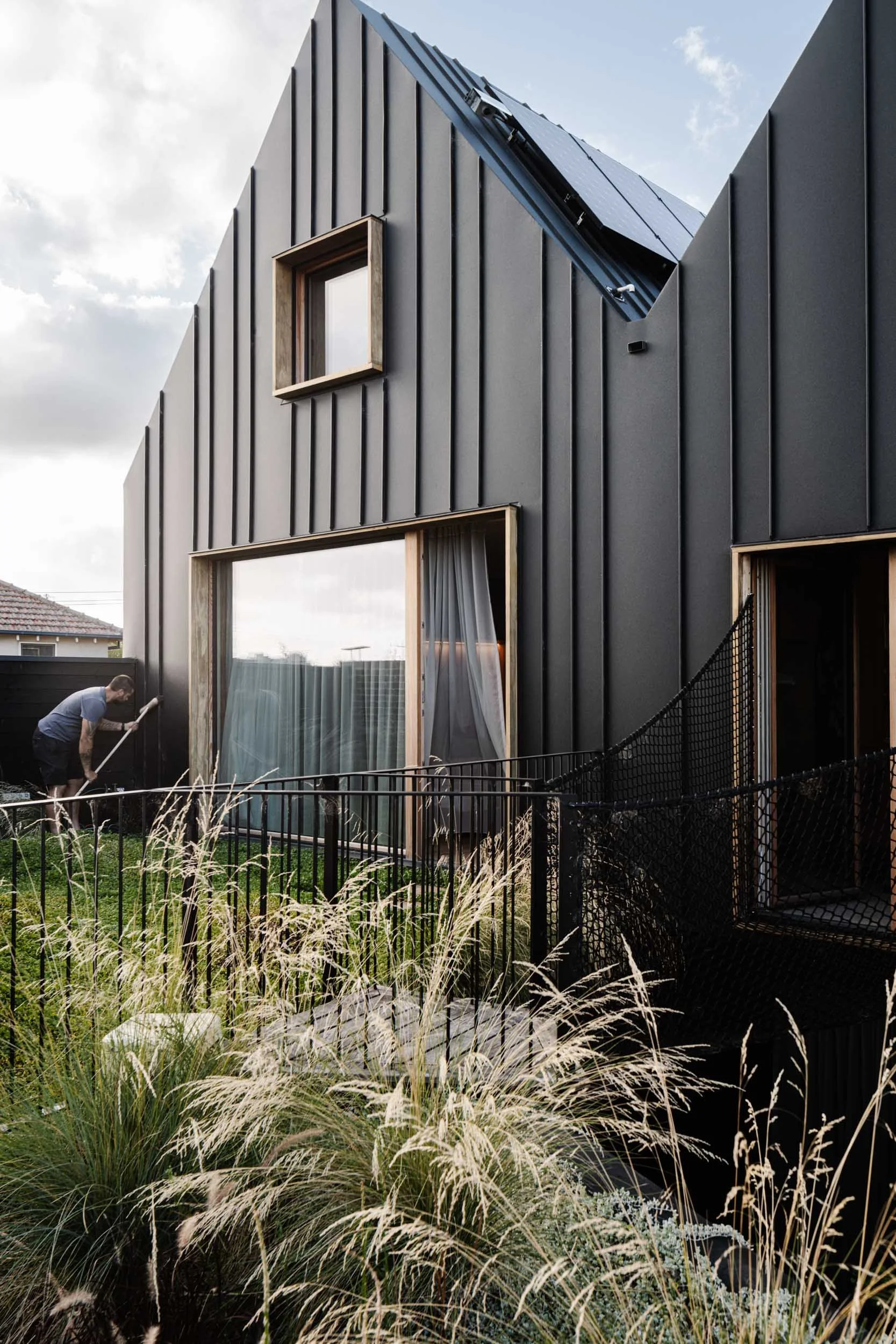 Black passivhaus with man sweeping cladding tilt-scroll