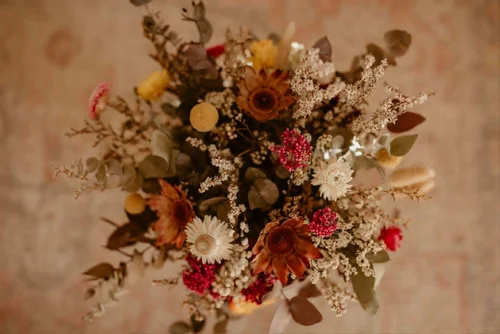 Dried banksia and eucalyptus arrangement in a rustic outdoor setting