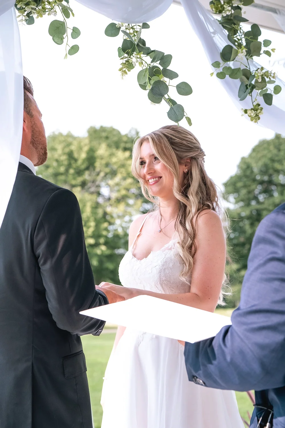 A bride and groom exchanging vows during an outdoor wedding ceremony