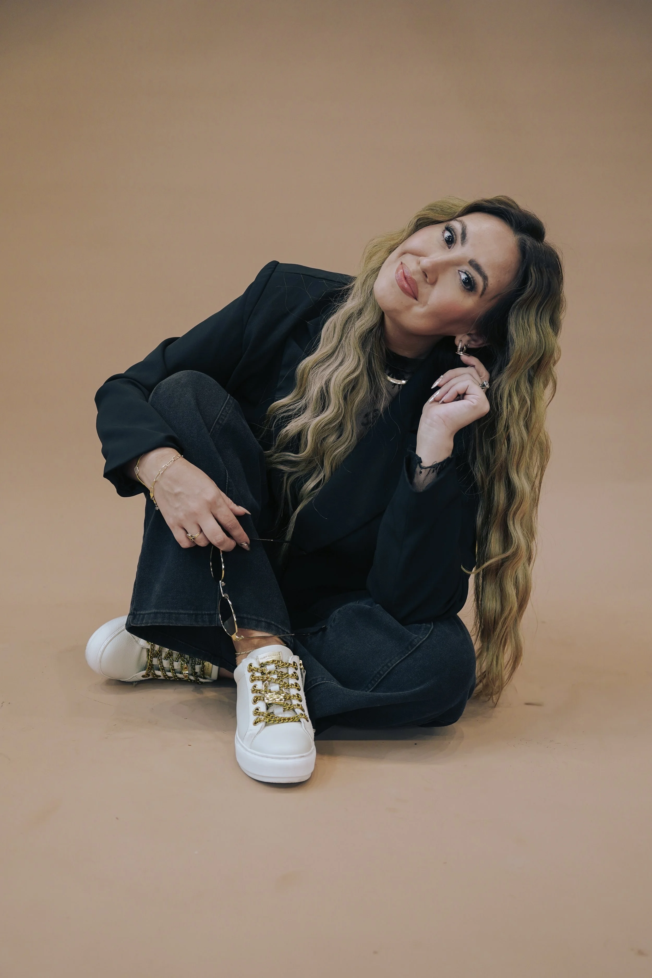 Hairstylist and salon owner at The Ember Room, a hair salon in Clermont, Florida, wearing a black blazer and jeans during a brand photoshoot.