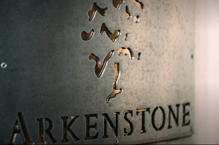 Close-up of a metal sign with the map of North America and the word "ARKENSTONE" engraved below.