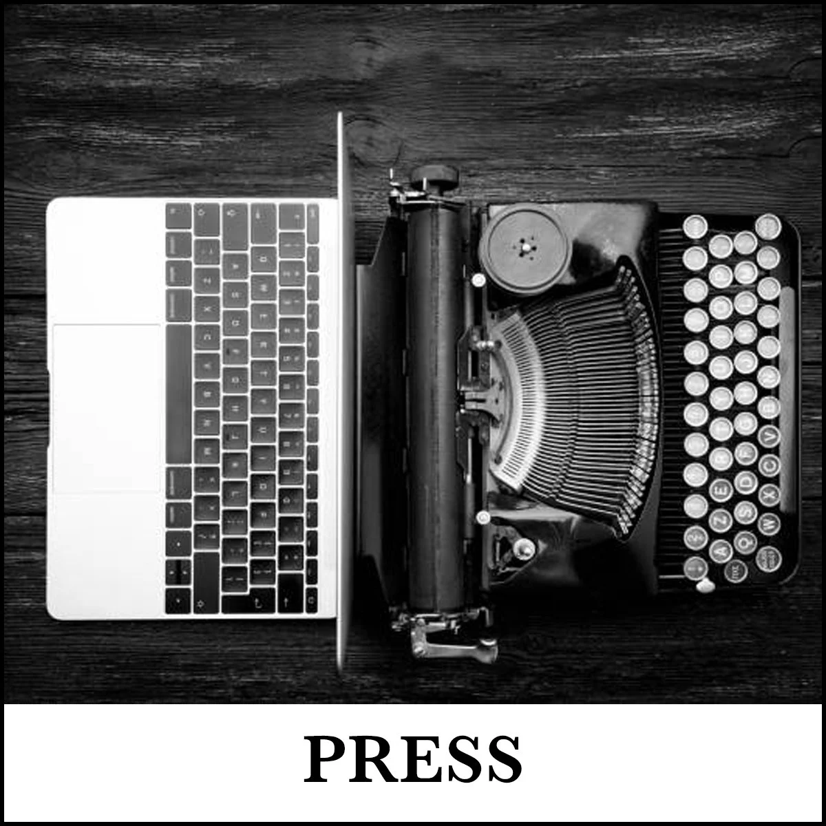 A vintage typewriter connected to a modern laptop on a wooden surface, with the word 'PRESS' written below.