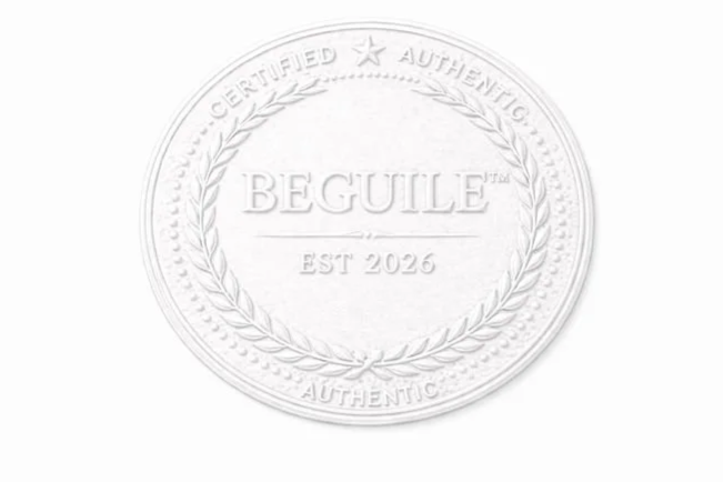 Embossed circular seal with the word 'BEGUILE' in the center, surrounded by a laurel wreath and the words 'CERTIFIED,' 'AUTHENTIC,' and 'AUTHENTIC' around the edge, with 'EST 2026' below.