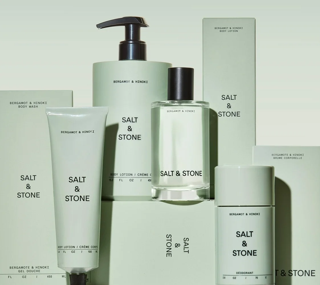 Collection of Salt & Stone skincare products including body wash, body lotion, perfume, body spray, deodorant, and body gel in minimalist light green packaging.