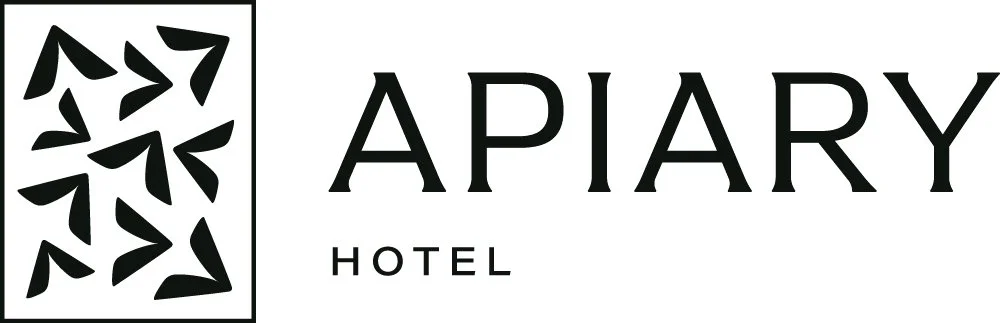 Logo of Apiary Hotel featuring black abstract honeycomb pattern on the left and the words 'Apiary Hotel' in black text on a white background.