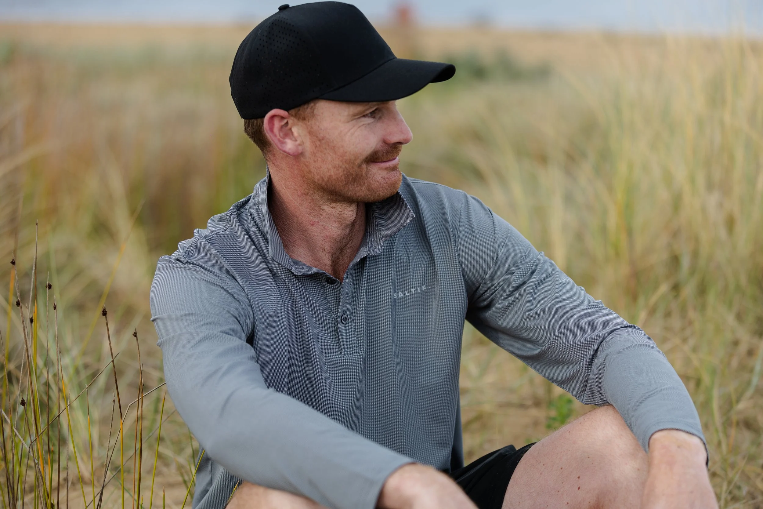 Field of white daisies with yellow centers, some in bloom and some budding, under warm sunlight.