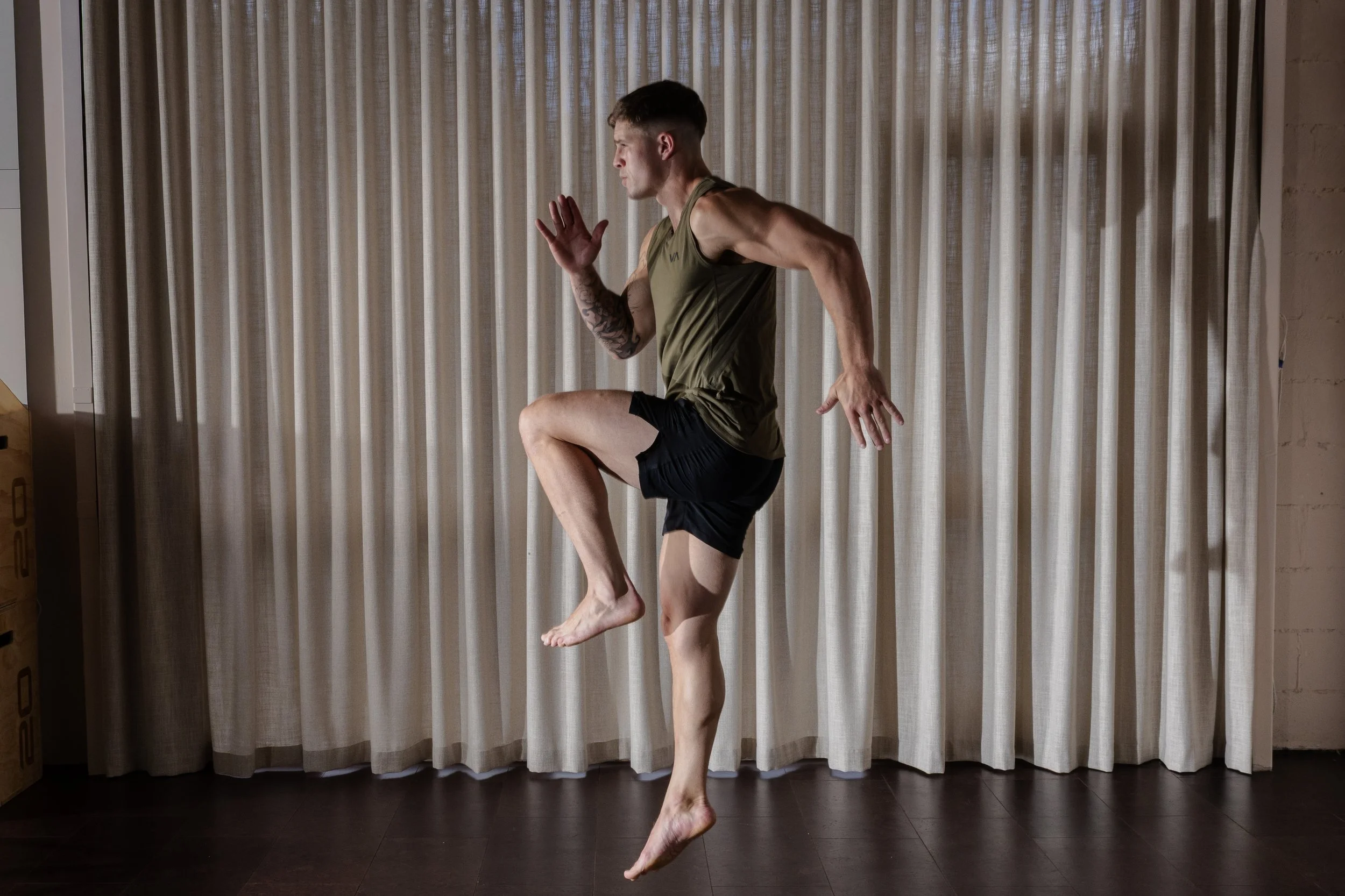 A modern backyard with a swimming pool, lounge chairs, a shaded sitting area, trees, and desert plants.