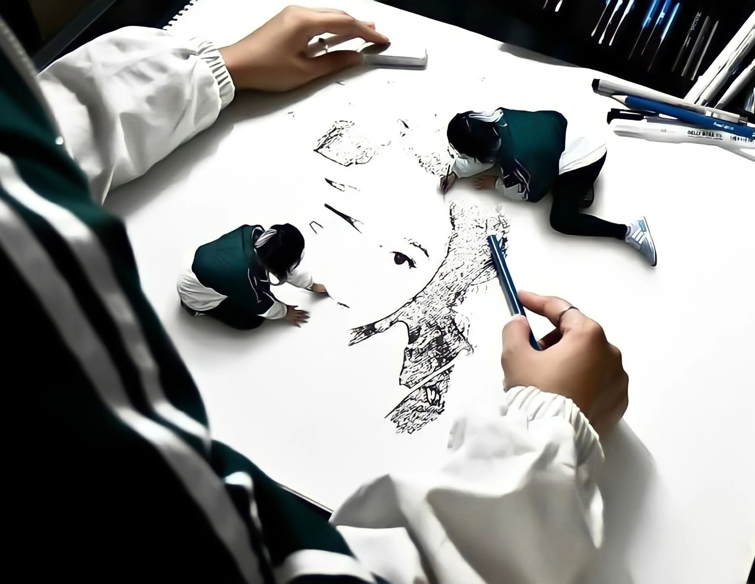 Miniature figures of children dressed in school uniforms drawing a detailed portrait of a face on a large white sheet of paper.
