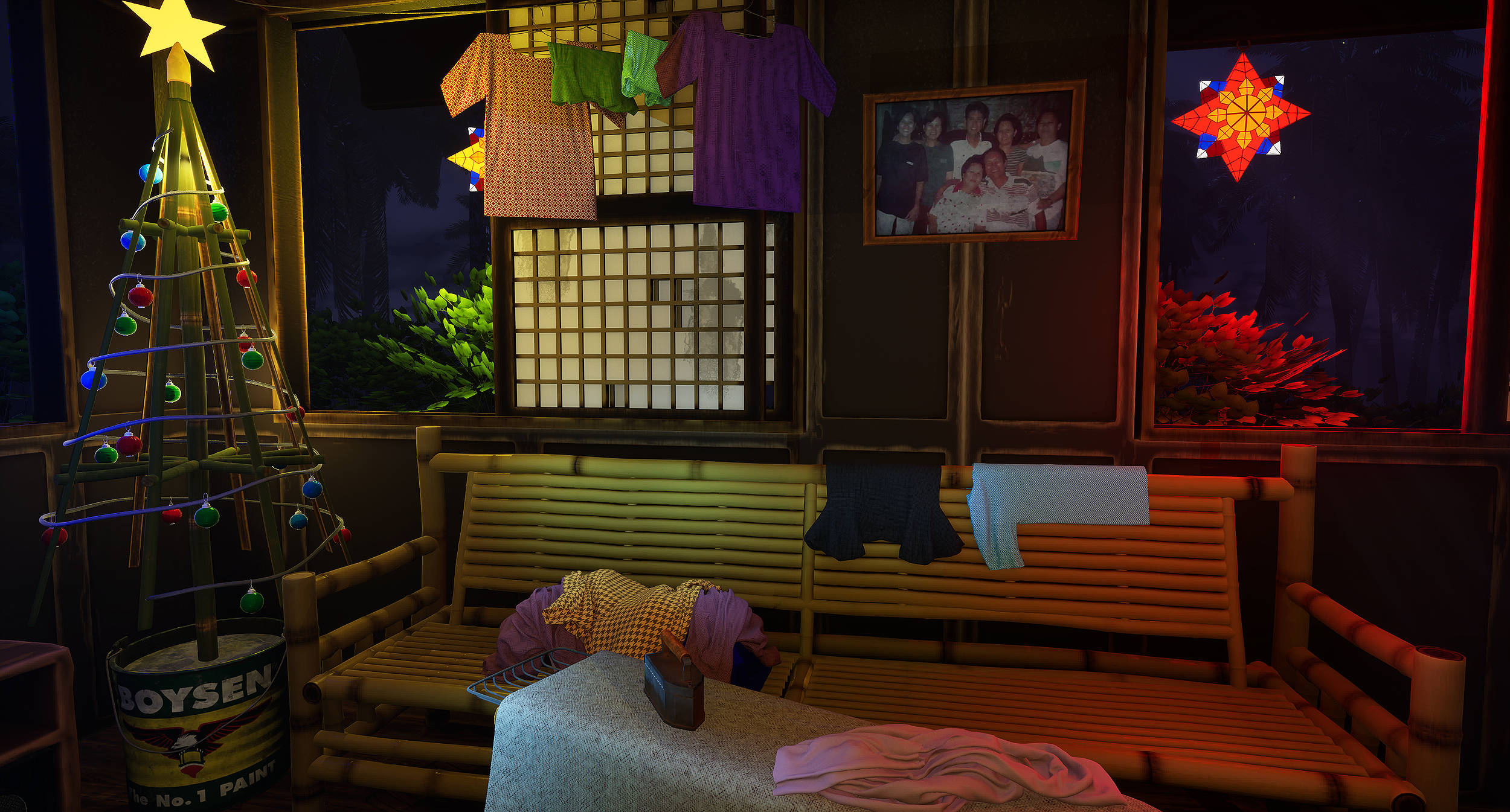 A festive room decorated with a small lit Christmas tree, colorful paper lanterns, hanging clothes, a framed family photo, and paper star lanterns, with a bamboo-style sofa and a table with clothes and a bottle.