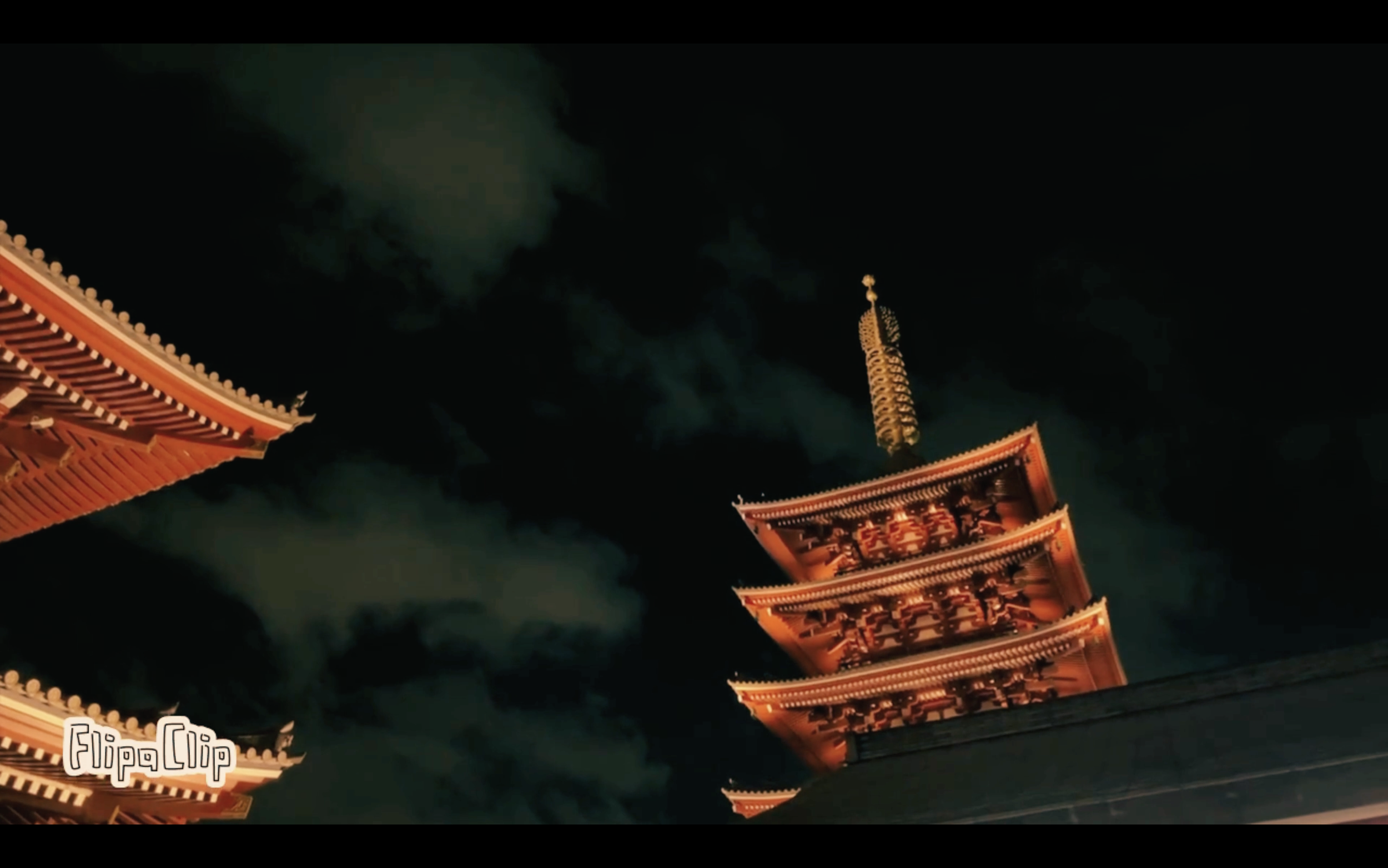 Nighttime photo of a traditional Japanese pagoda with multiple tiers illuminated against a dark sky.